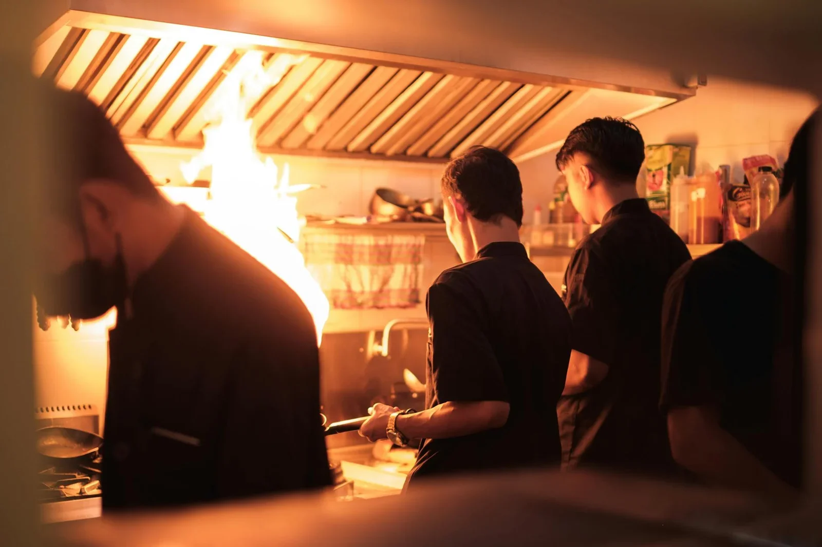 Professional chefs working in a busy industrial kitchen with | Thiết kế nội thất 24