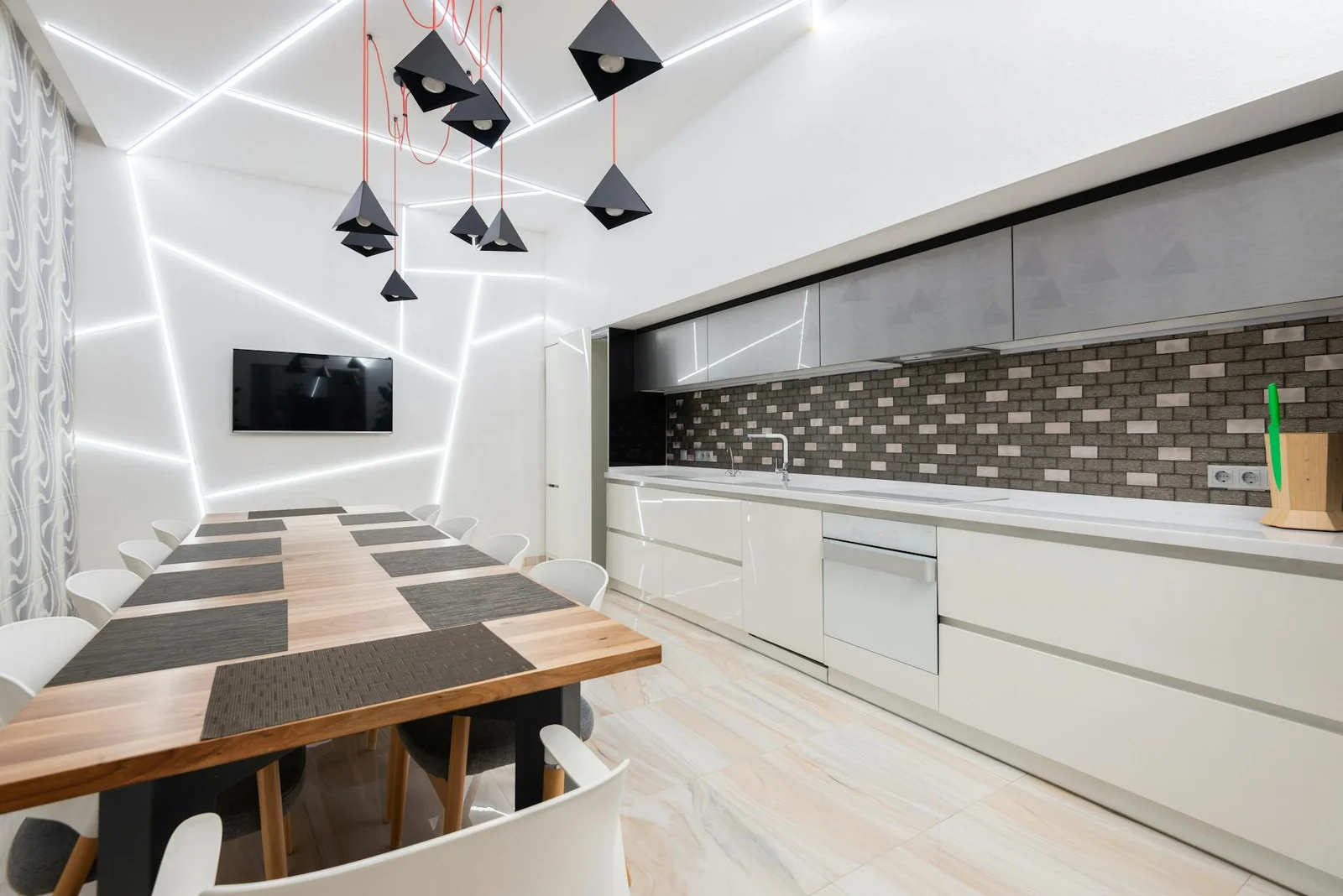 Thiết kế bếp tối giản với tủ trắng tinh khôi và chiếc bàn gỗ tự nhiên được chiếu sáng bởi đèn chùm độc đáo. | Thiết kế nội thất 24