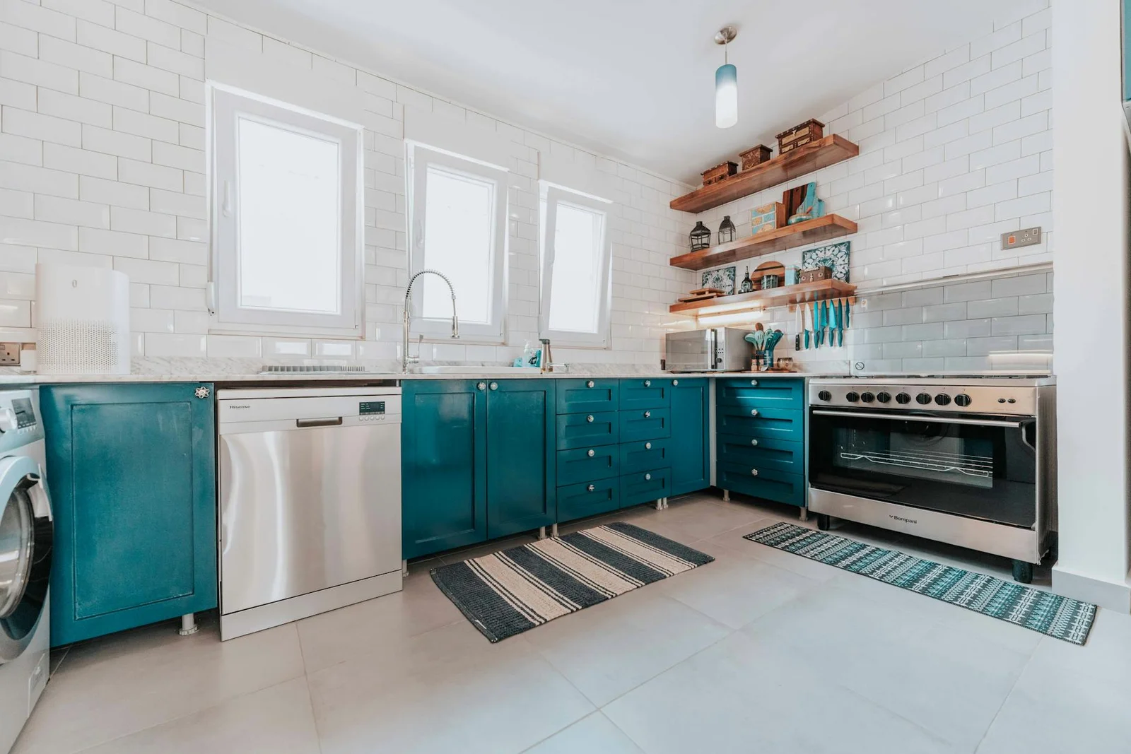 Không gian bếp sáng sủa nổi bật với hệ tủ xanh dương cùng thiết bị inox bóng bẩy và kệ mở tiện nghi hiện đại. | Thiết kế nội thất 24