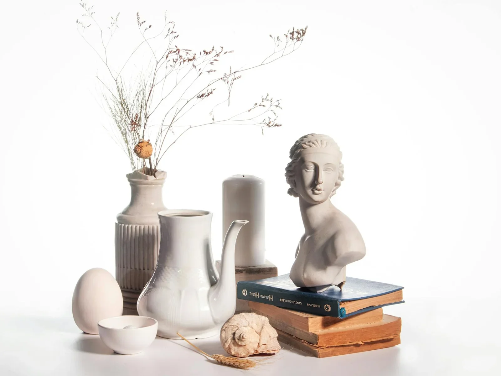 Artistic still life featuring ceramics, books, and a bust fo | Thiết kế nội thất 24