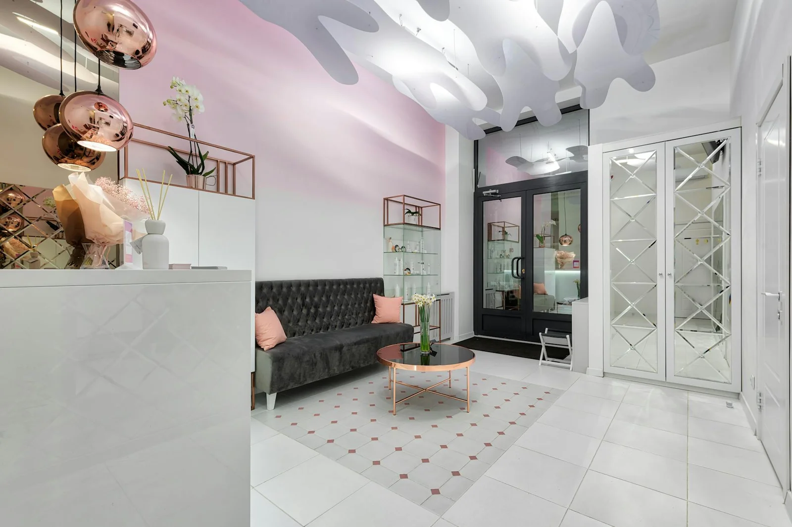 Tiền sảnh hiện đại nổi bật với ghế sofa, bàn trà kê sát cửa, nền gạch hoa văn và chùm đèn kim loại tỏa sáng. | Thiết kế nội thất 24