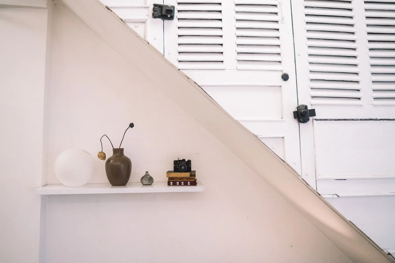 A minimalist shelf decor featuring a vintage camera, a brown | Thiết kế nội thất 24