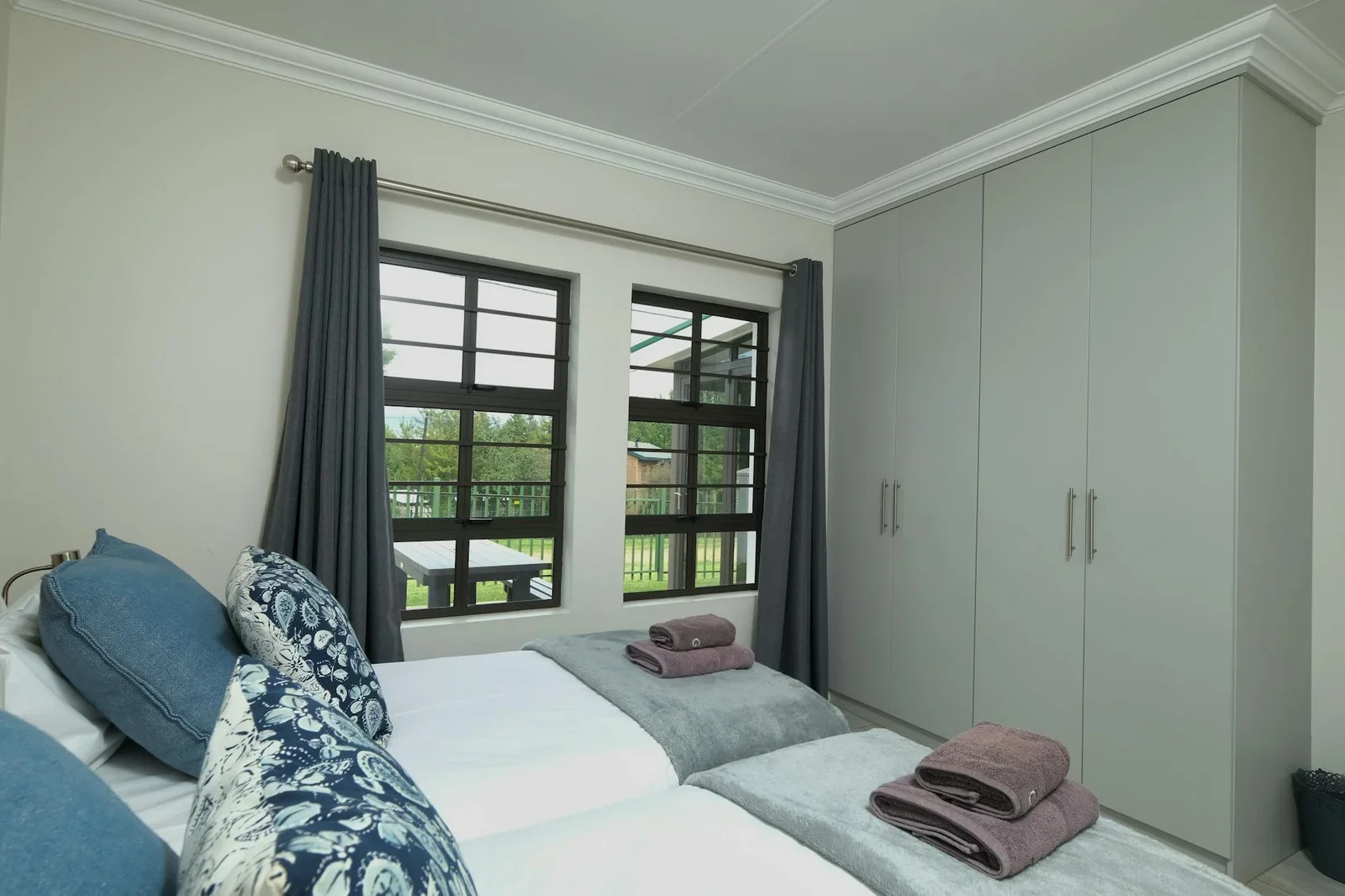 Thiết kế phòng ngủ đương đại với giường ngủ chỉn chu, hướng nhìn ra vườn xanh mát cùng khu vực học tập yên tĩnh. | Thiết kế nội thất 24