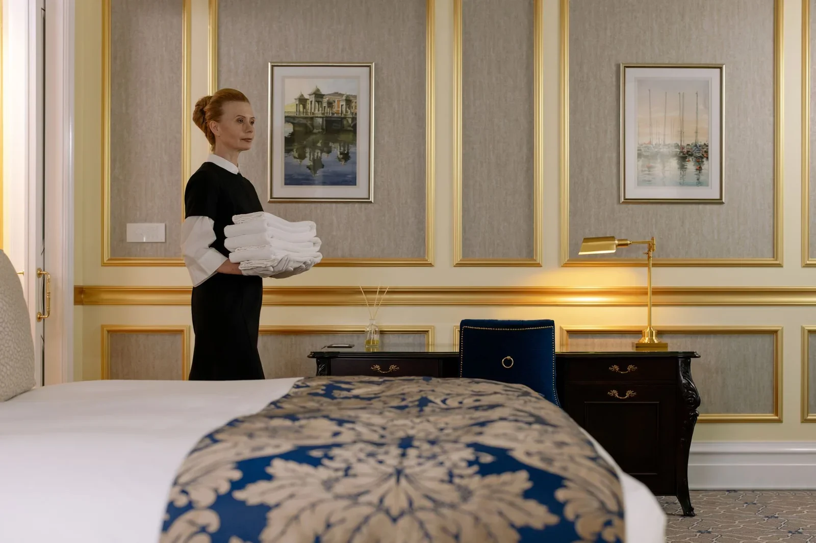 A housekeeper holding towels in a luxurious hotel room with  | Thiết kế nội thất 24