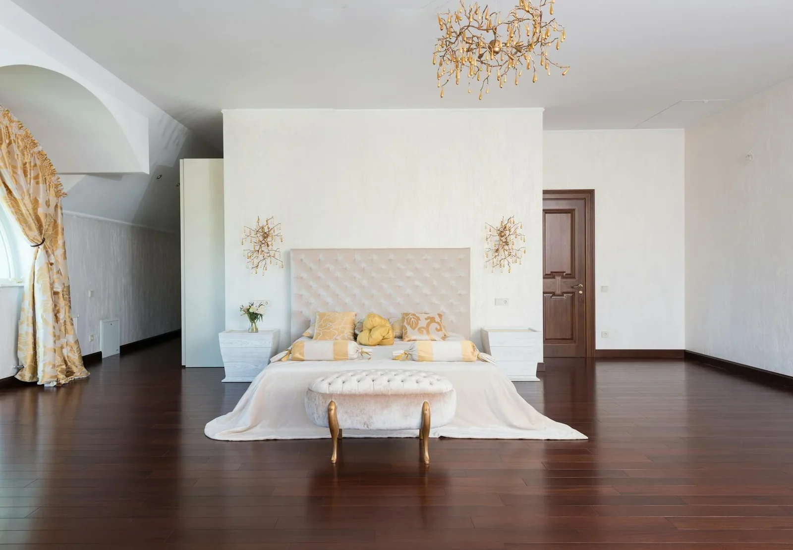 Phòng ngủ chữ nhật rộng rãi tràn ngập ánh sáng, bố trí giường queen size, tựa lưng êm ái cùng chi tiết đồng vàng và đèn chùm tinh tế. | Thiết kế nội thất 24