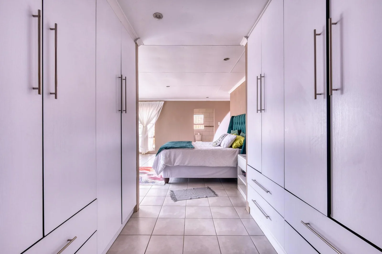 Hệ tủ trắng tinh tế phối cùng decor tối giản, điểm xuyết sắc cam ấm áp cho góc nghỉ ngơi thêm phần thanh lịch. | Thiết kế nội thất 24