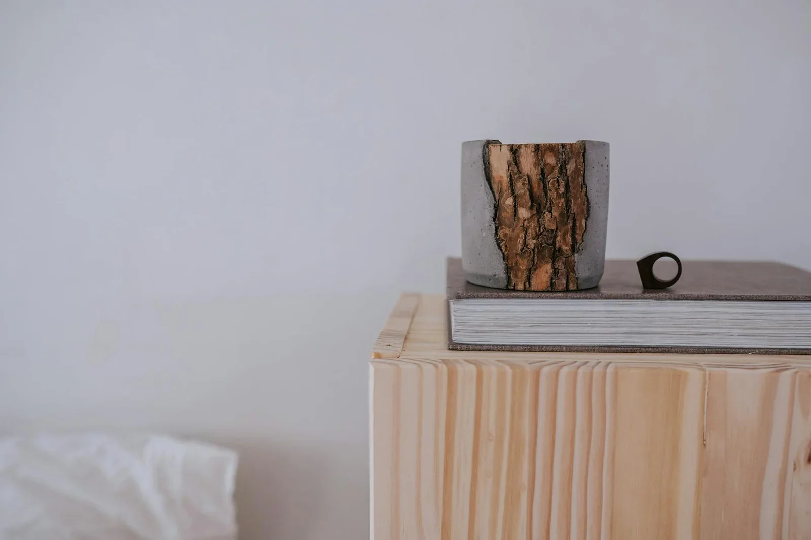 Góc trang trí Japandi nghệ thuật với chậu gỗ mộc, chồng sách xếp gọn trên khối gỗ vuông, tôn lên vẻ đẹp tĩnh lặng. | Thiết kế nội thất 24