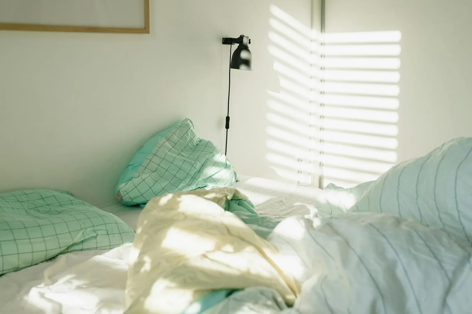 A sunlit Scandinavian-style bed with soft pillows and blanke | Thiết kế nội thất 24