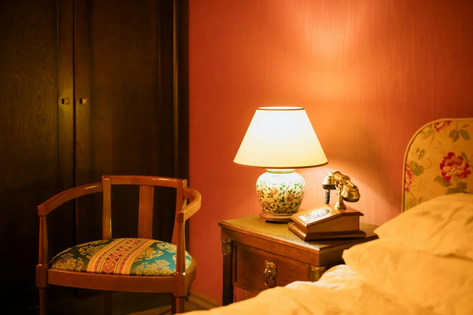 Phòng ngủ vintage ấm cúng bài trí đèn bàn cổ điển, ghế tựa và điện thoại cạnh giường gợi nét hoài niệm tinh tế. | Thiết kế nội thất 24