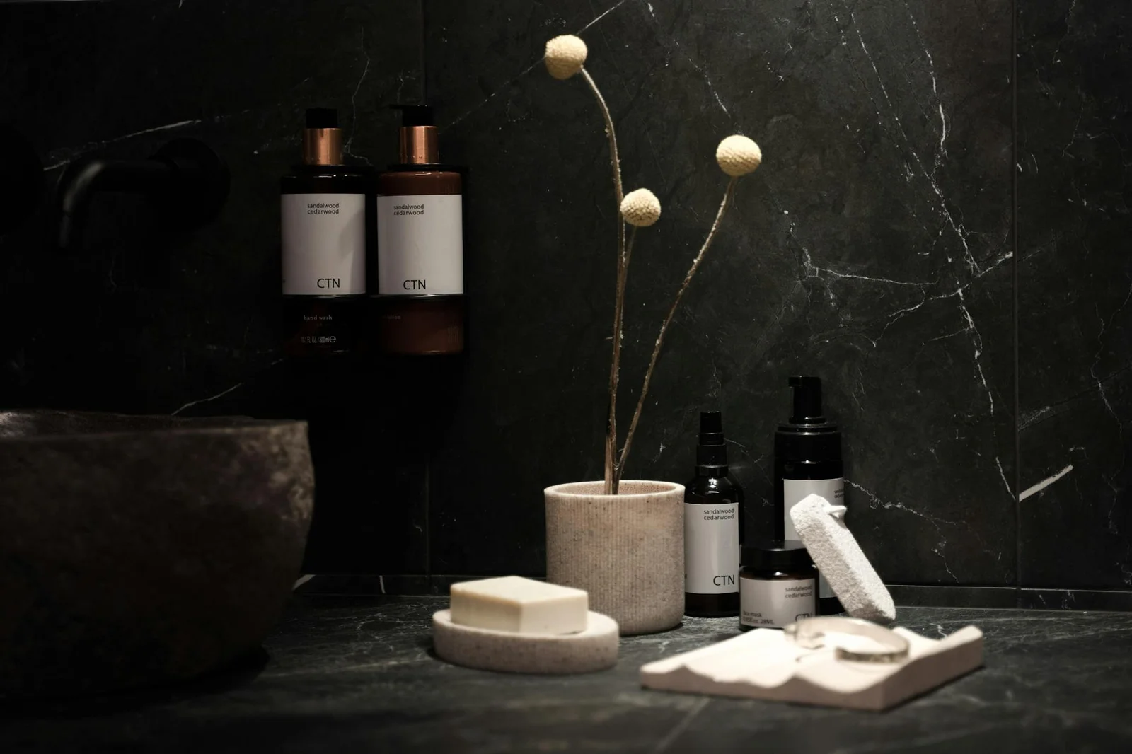 Góc spa tối giản trưng bày bánh xà phòng và phụ kiện trang trí tinh tế trên mặt bàn đá cẩm thạch đen bóng. | Thiết kế nội thất 24