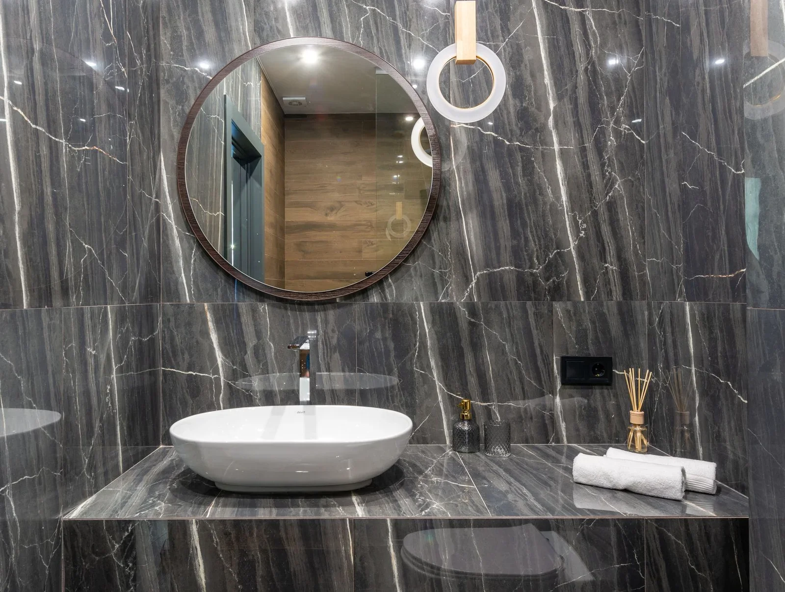 Elegant bathroom featuring a modern sink, round mirror, and  | Thiết kế nội thất 24