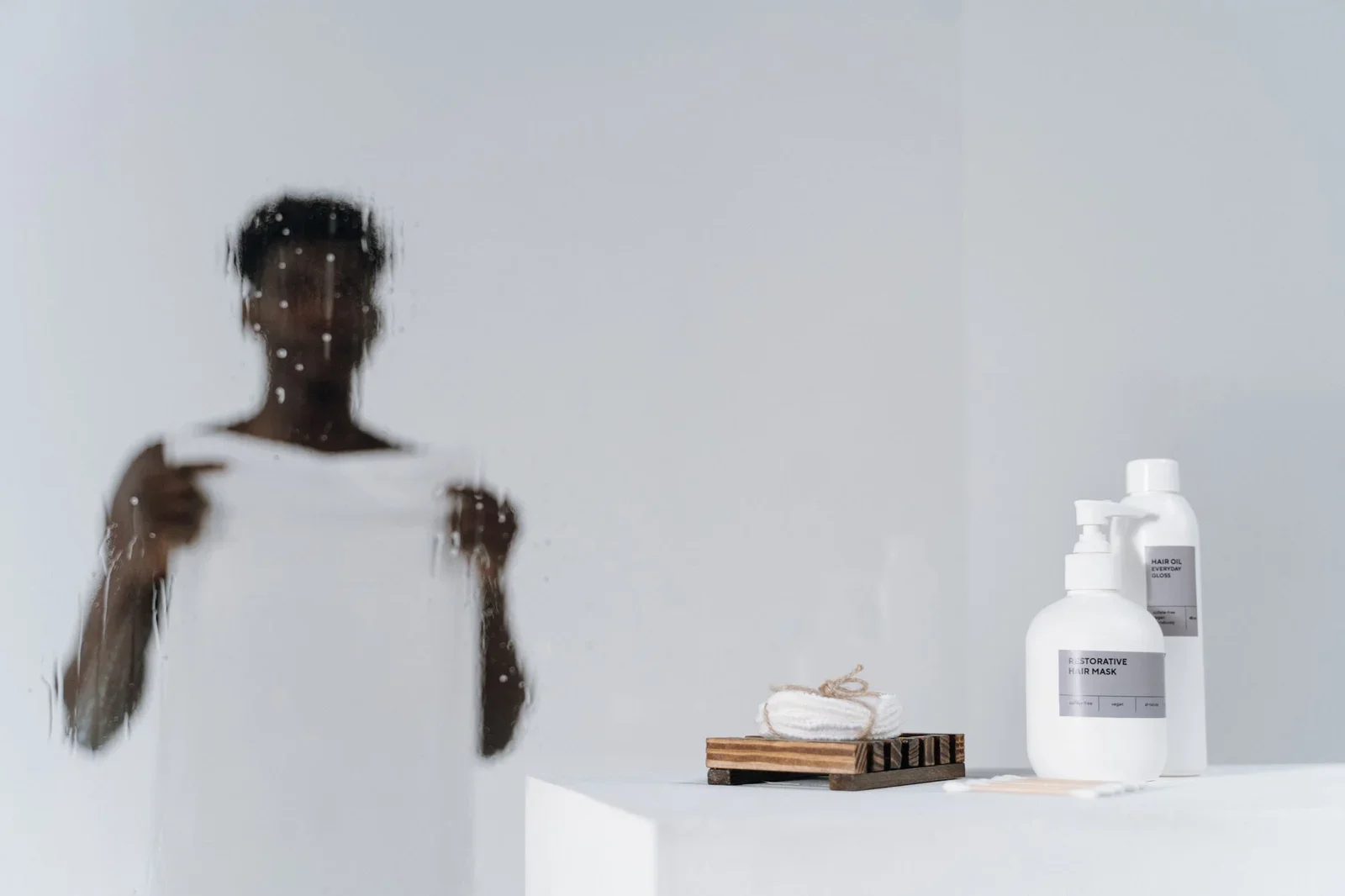 Blurred reflection of a man with skincare bottles on a white | Thiết kế nội thất 24