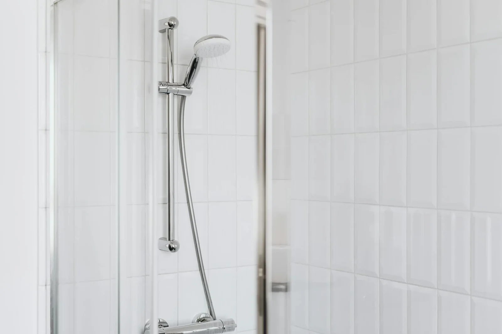Stylish shower setup with chrome fixtures and clean white ti | Thiết kế nội thất 24