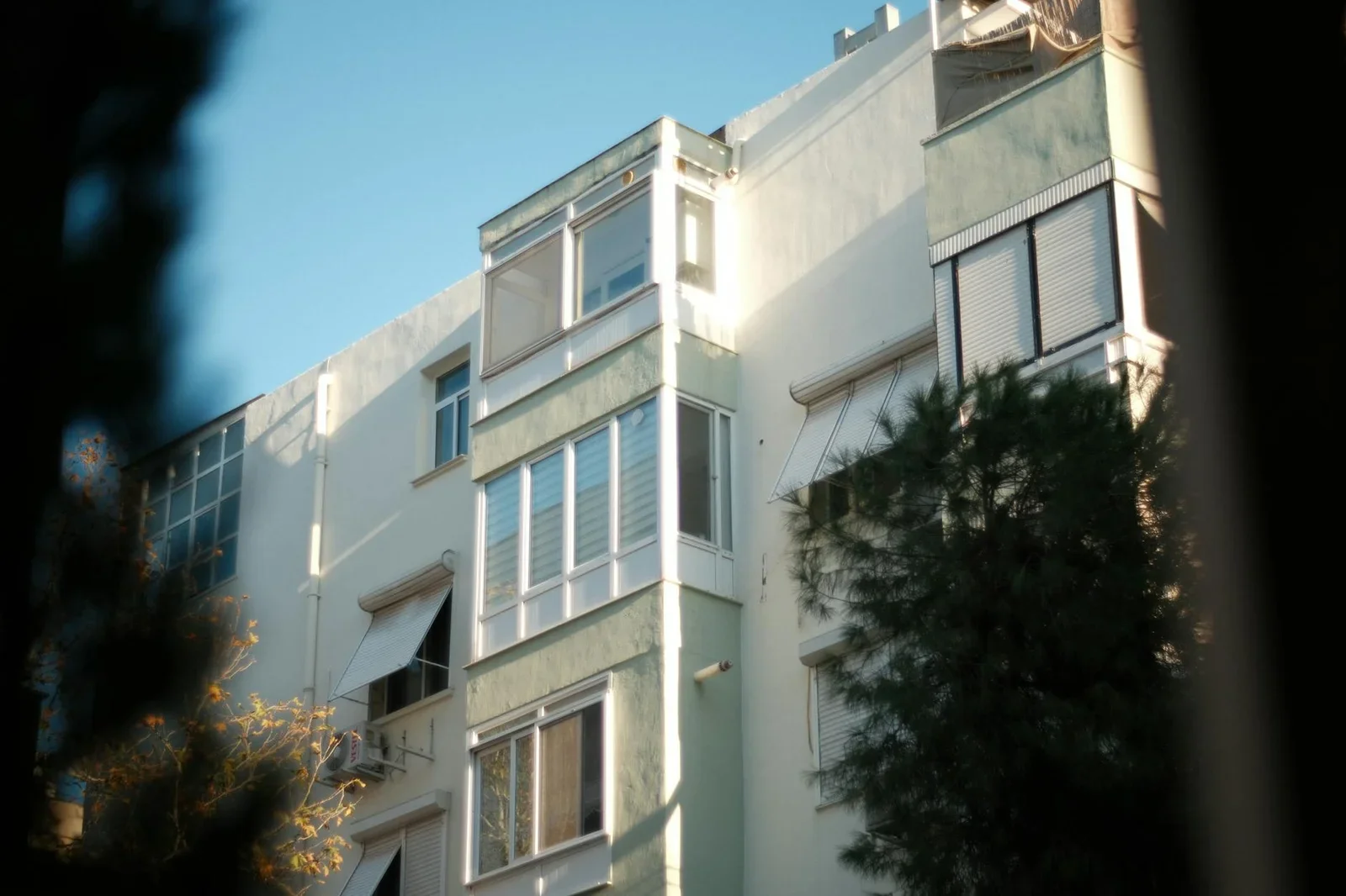 Sunlit facade of a modern apartment building with green acce | Thiết kế nội thất 24