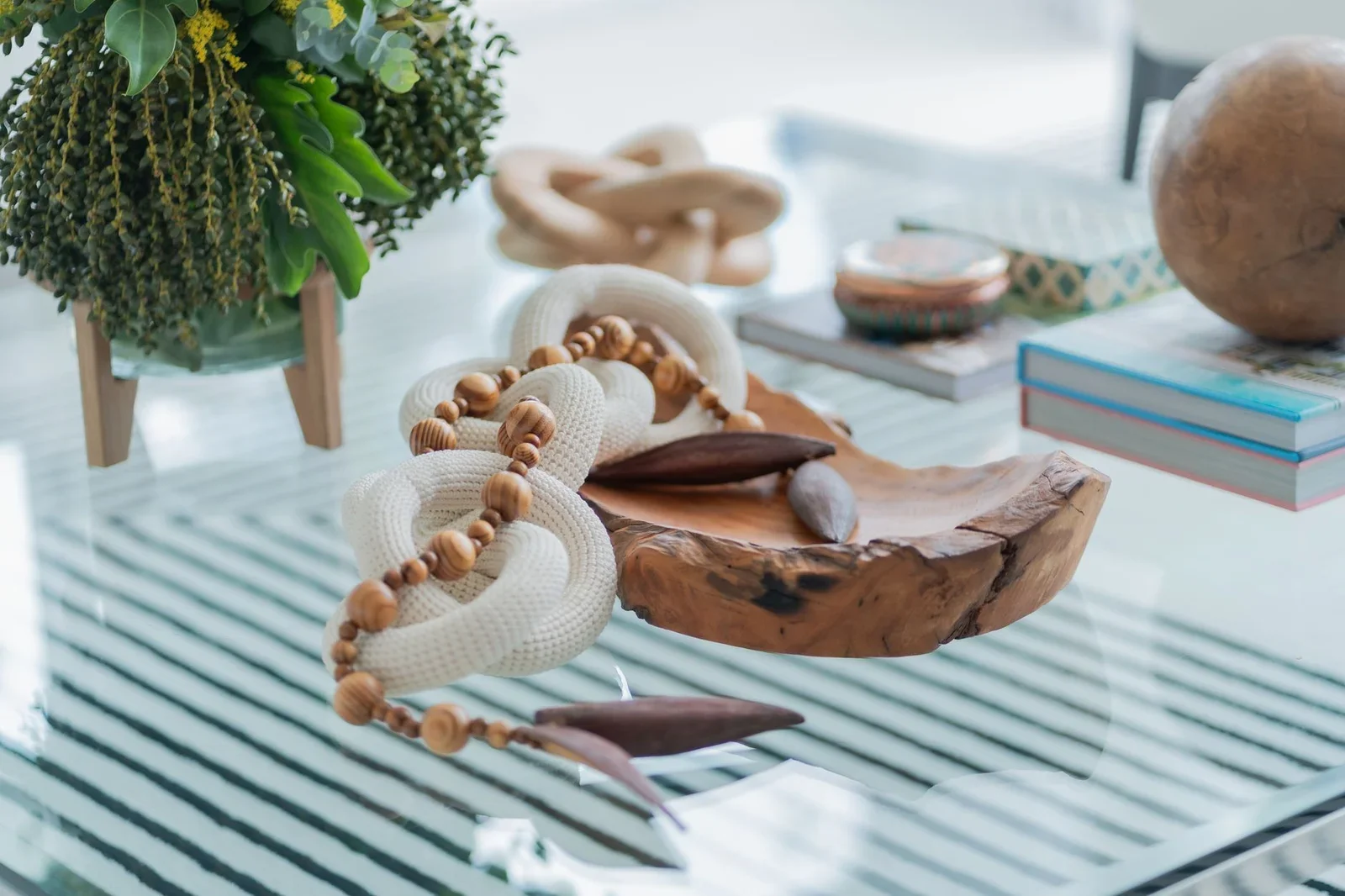 Phụ kiện thủ công bằng gỗ và dây thừng đặt trên bàn kính tạo điểm nhấn mộc mạc cho không gian hiện đại. | Thiết kế nội thất 24