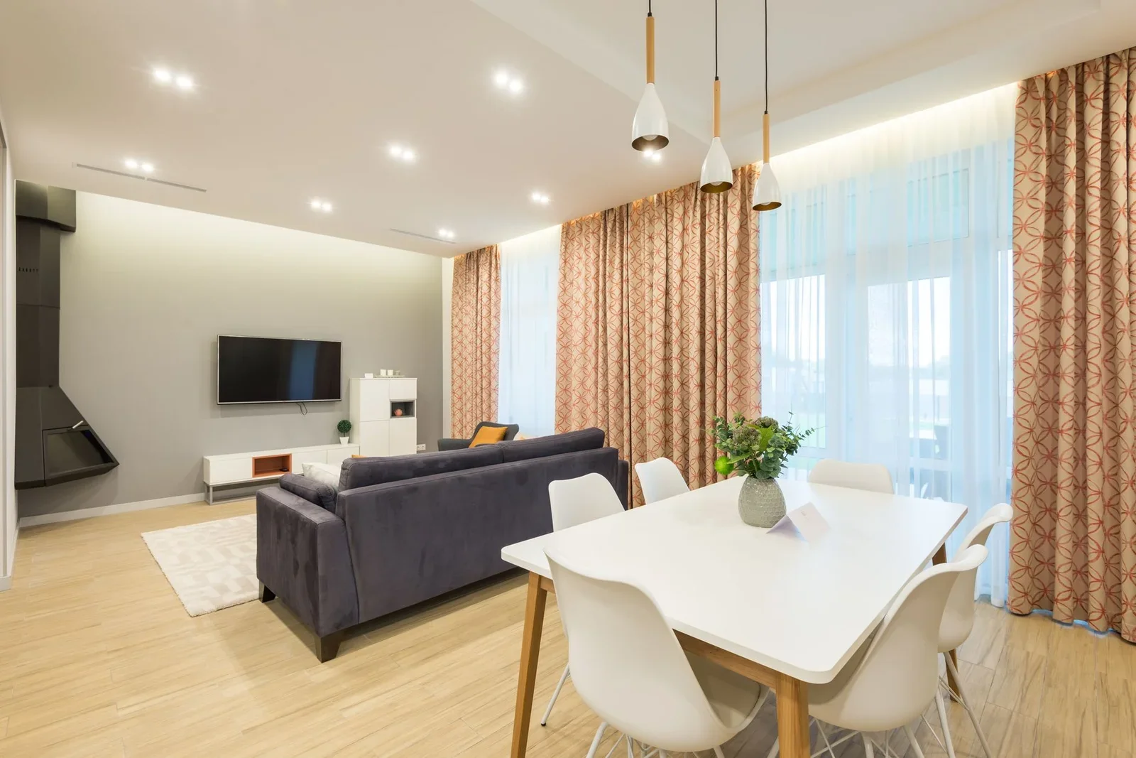 Bàn trắng tinh khôi điểm xuyết cây xanh cạnh lò sưởi và tivi, kiến tạo không gian giải trí hài hòa và thoáng đãng. | Thiết kế nội thất 24