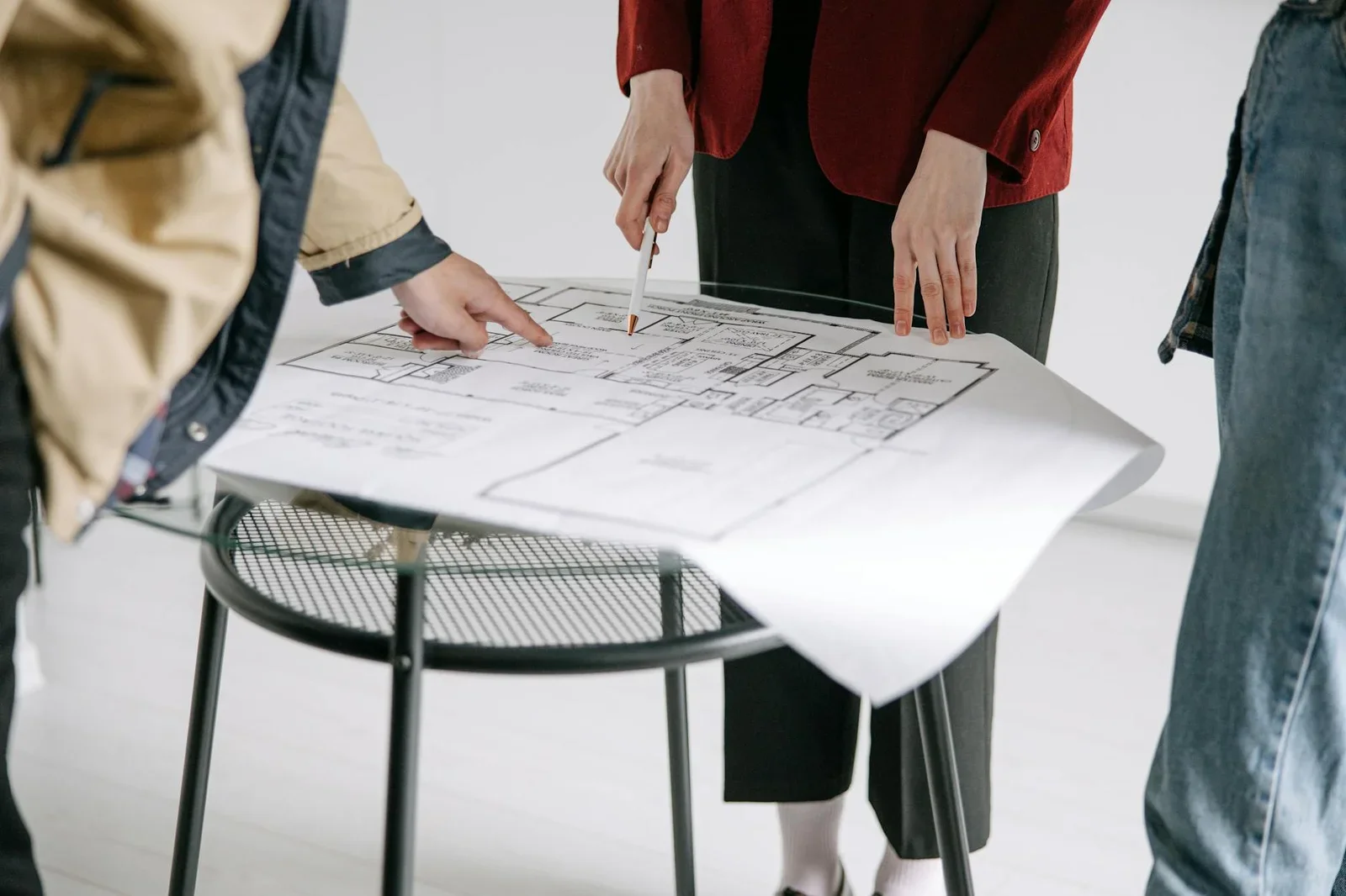 A group of people reviewing architectural blueprints on a ta | Thiết kế nội thất 24