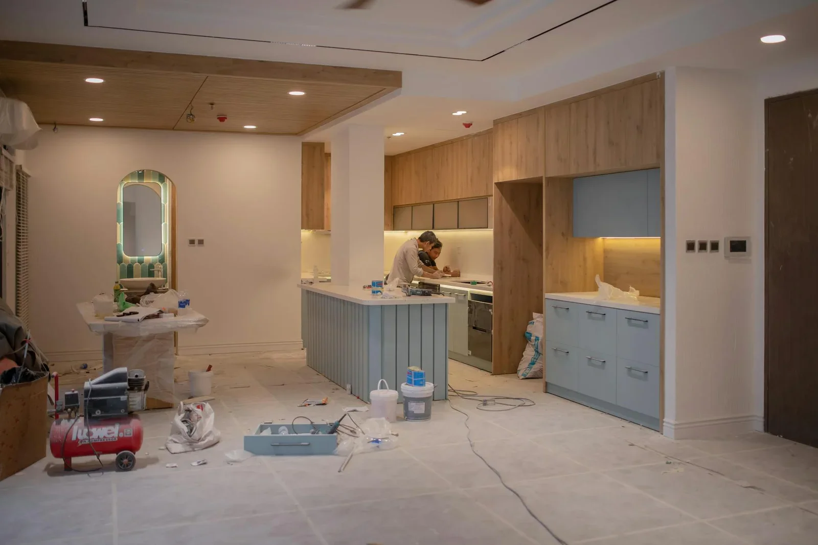 A modern kitchen undergoing renovation, featuring a worker,  | Thiết kế nội thất 24