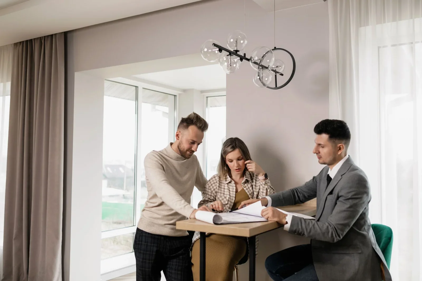 A couple consults with a real estate agent in a modern indoo | Thiết kế nội thất 24