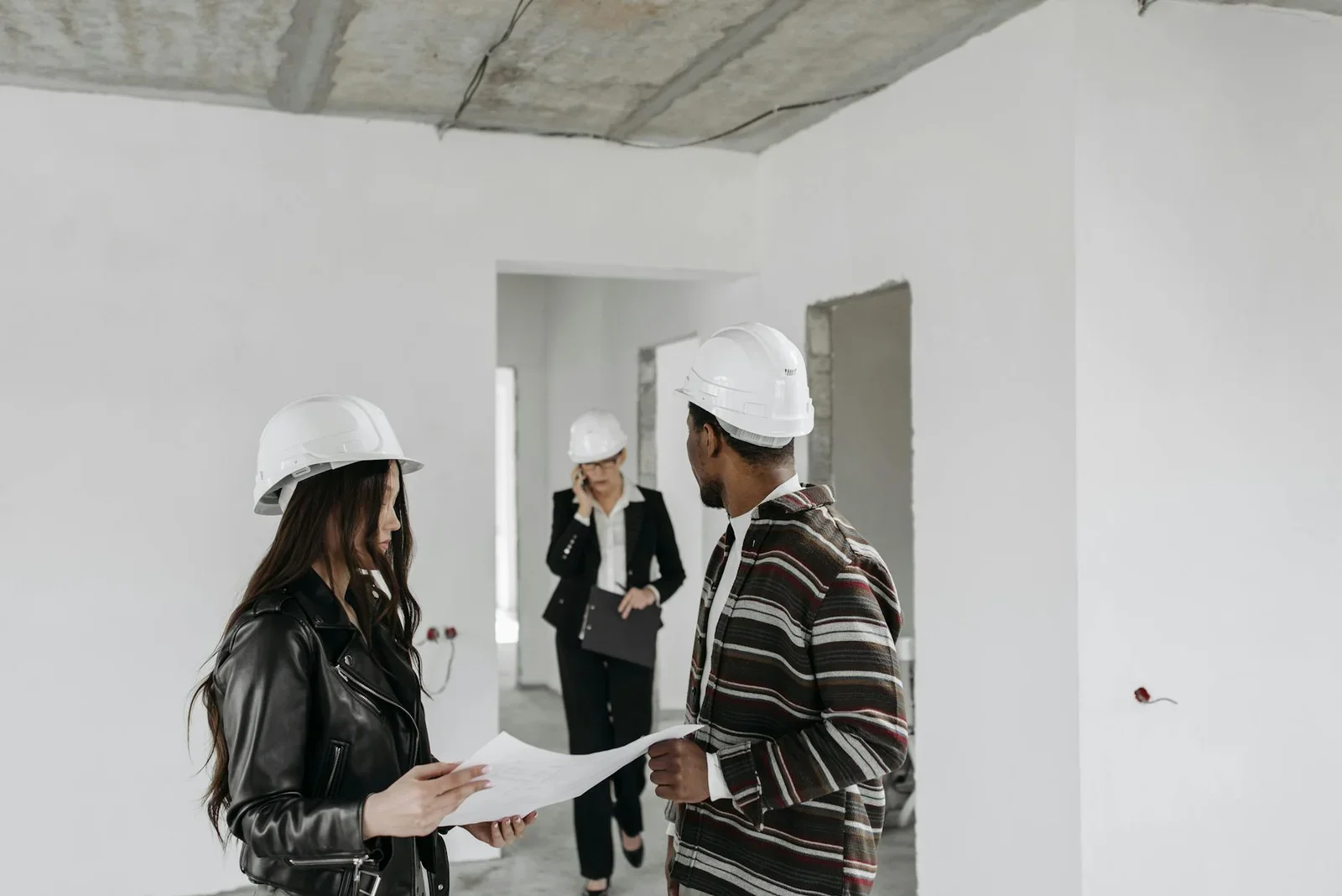 Diverse construction team in hard hats reviewing blueprints  | Thiết kế nội thất 24