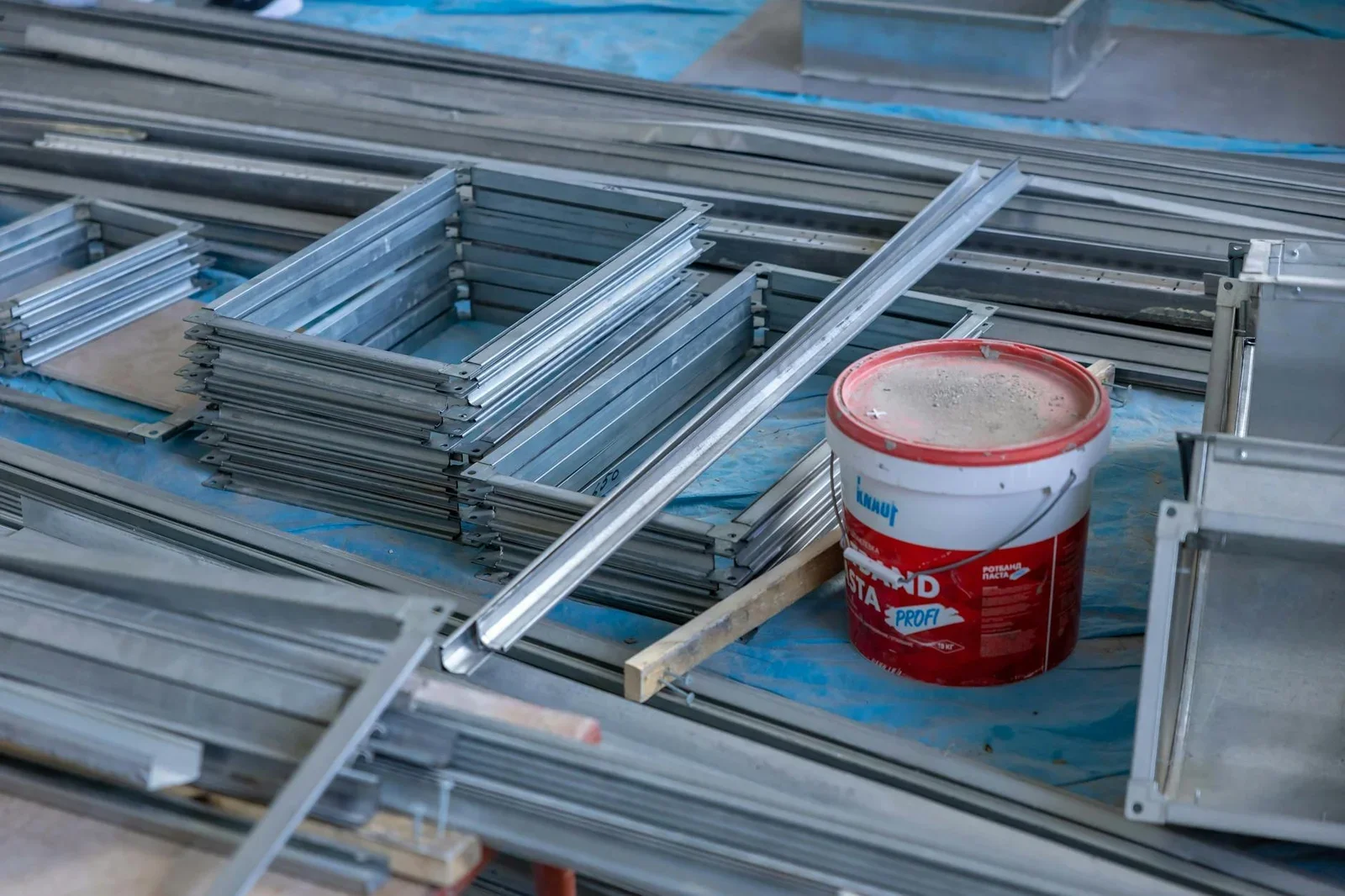 Stacks of metal frames and a paint bucket inside a construct | Thiết kế nội thất 24