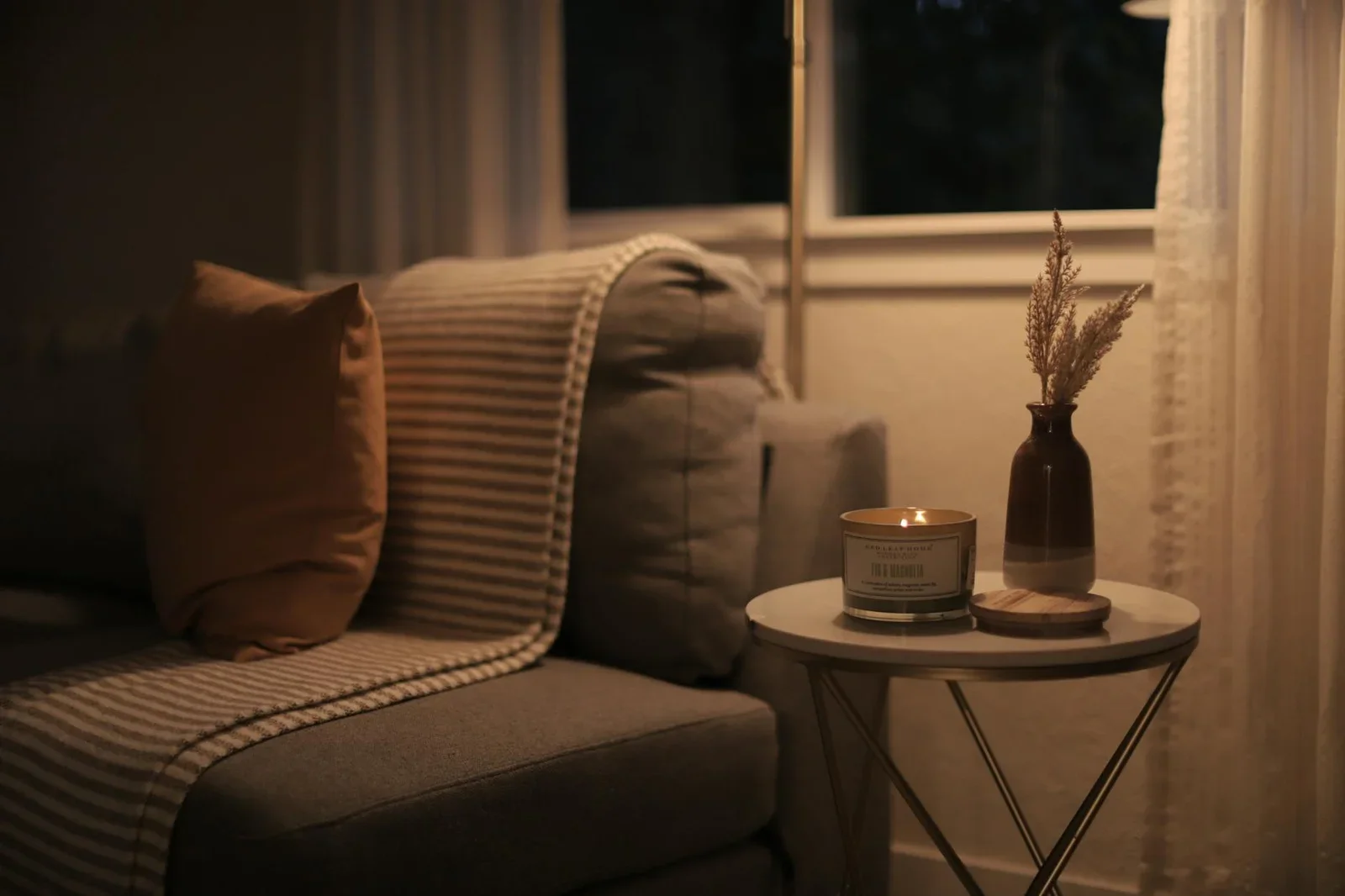 Ánh nến ấm áp cùng sofa êm ái và phụ kiện trang trí tạo không gian thư giãn, minh họa bố cục phòng khách. | Thiết kế nội thất 24