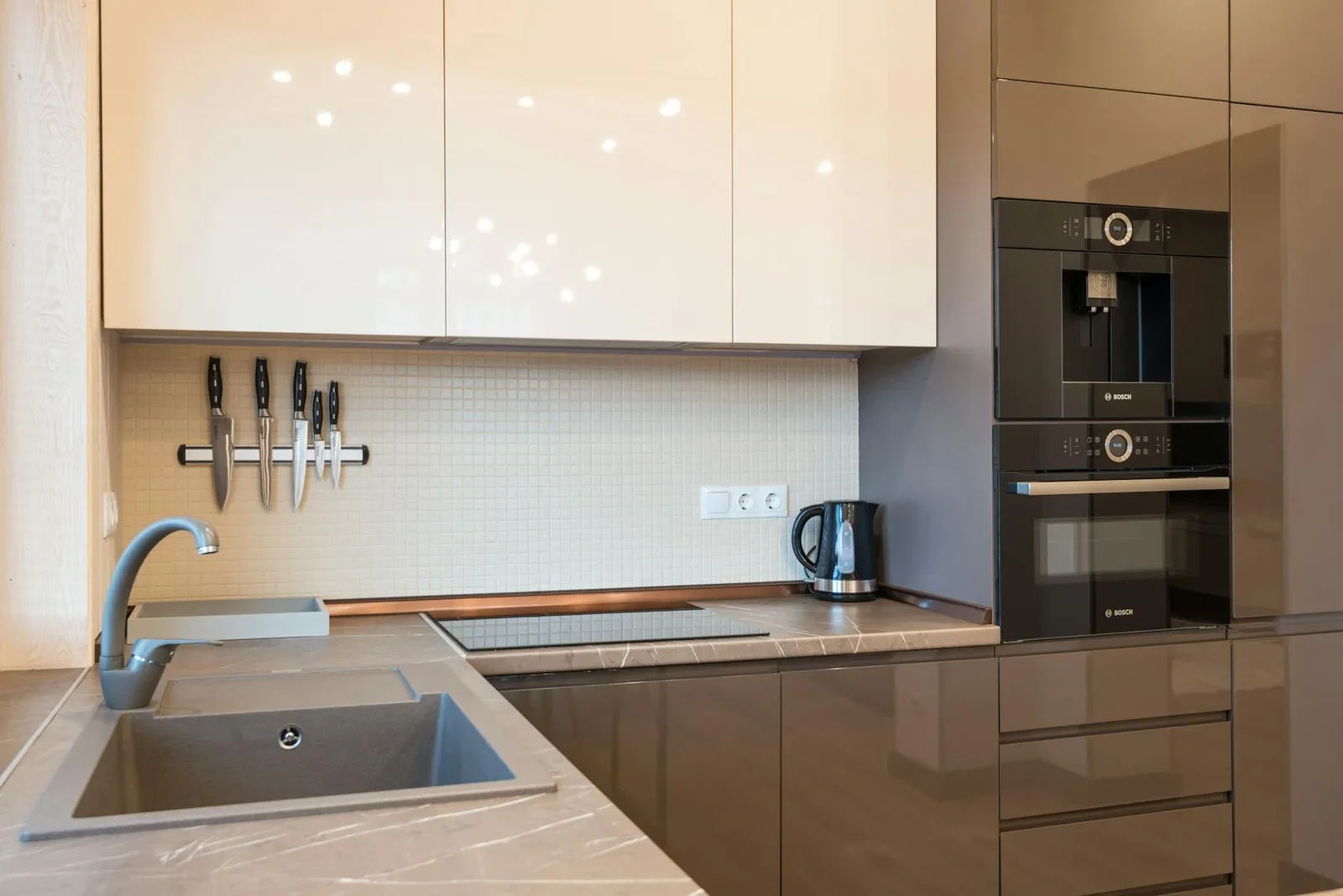 Bếp phong cách tối giản với nội thất bề mặt sáng bóng, thiết bị hiện đại, ánh sáng tự nhiên tràn ngập không gian sống. | Thiết kế nội thất 24
