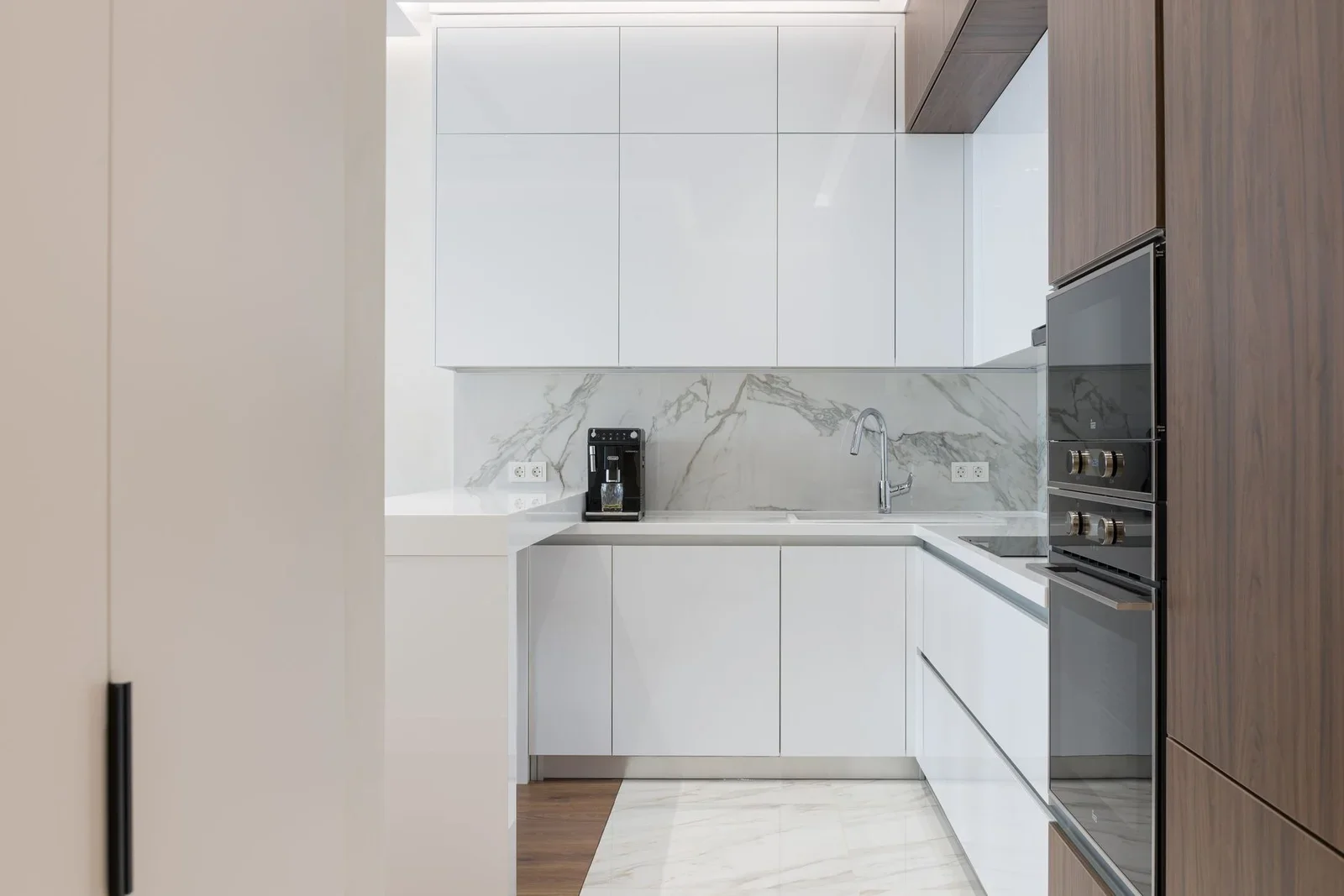 Bếp nhỏ phong cách tối giản với tủ gỗ trắng, thiết bị hiện đại và ánh sáng tự nhiên giúp không gian thoáng đãng. | Thiết kế nội thất 24