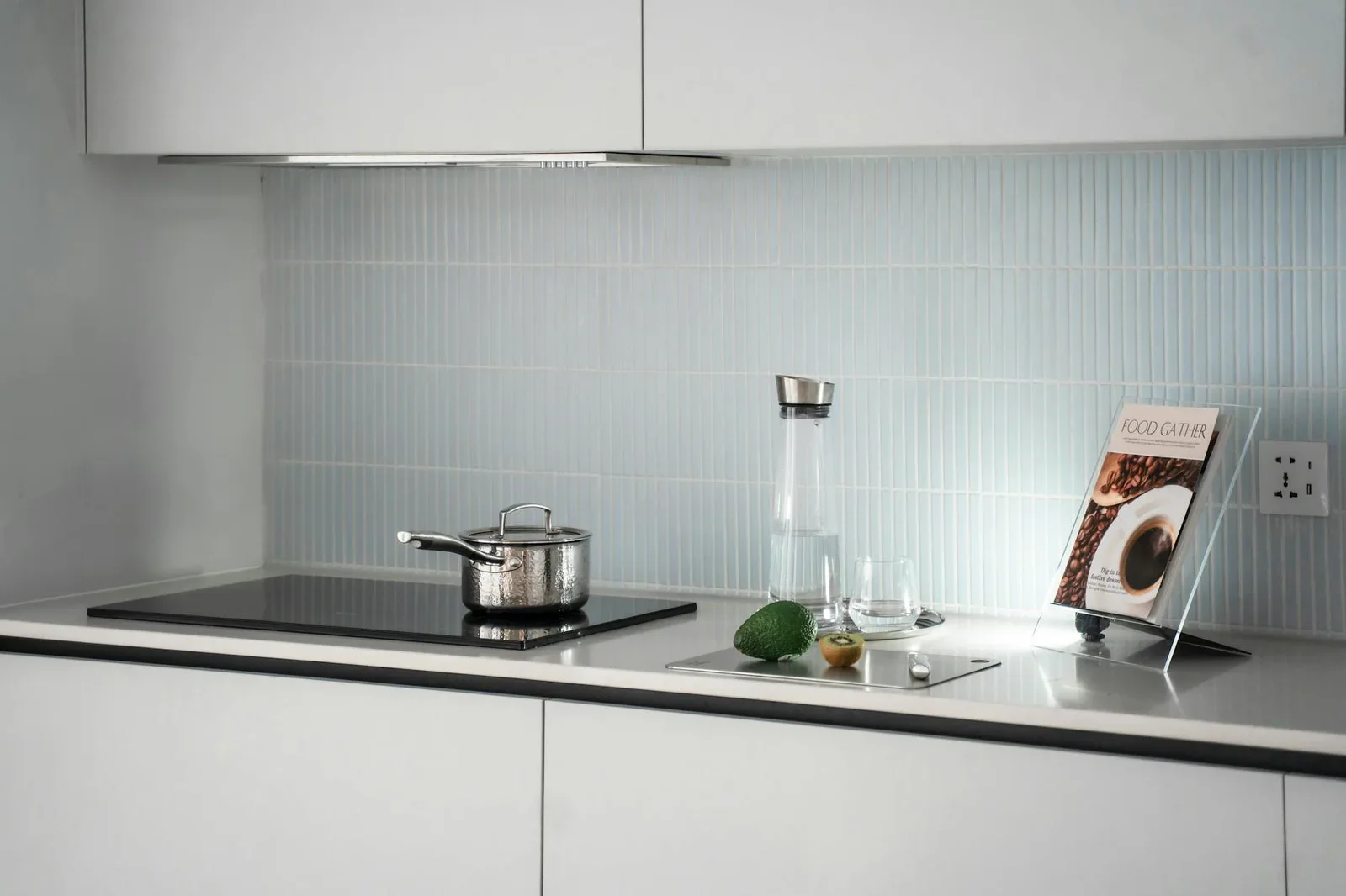 Mặt bếp tối giản sang trọng tích hợp bếp từ, bộ nồi thủy tinh và sách nấu ăn, tối ưu không gian nhà ống. | Thiết kế nội thất 24