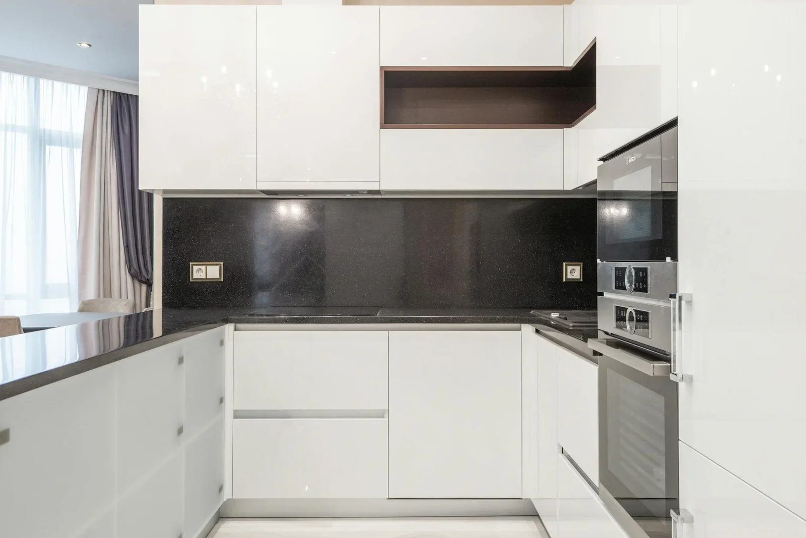 Tủ bếp trắng tối giản phối chi tiết đen tương phản, tạo vẻ đẹp hiện đại cùng sự gọn gàng tối ưu cho nhà ống. | Thiết kế nội thất 24