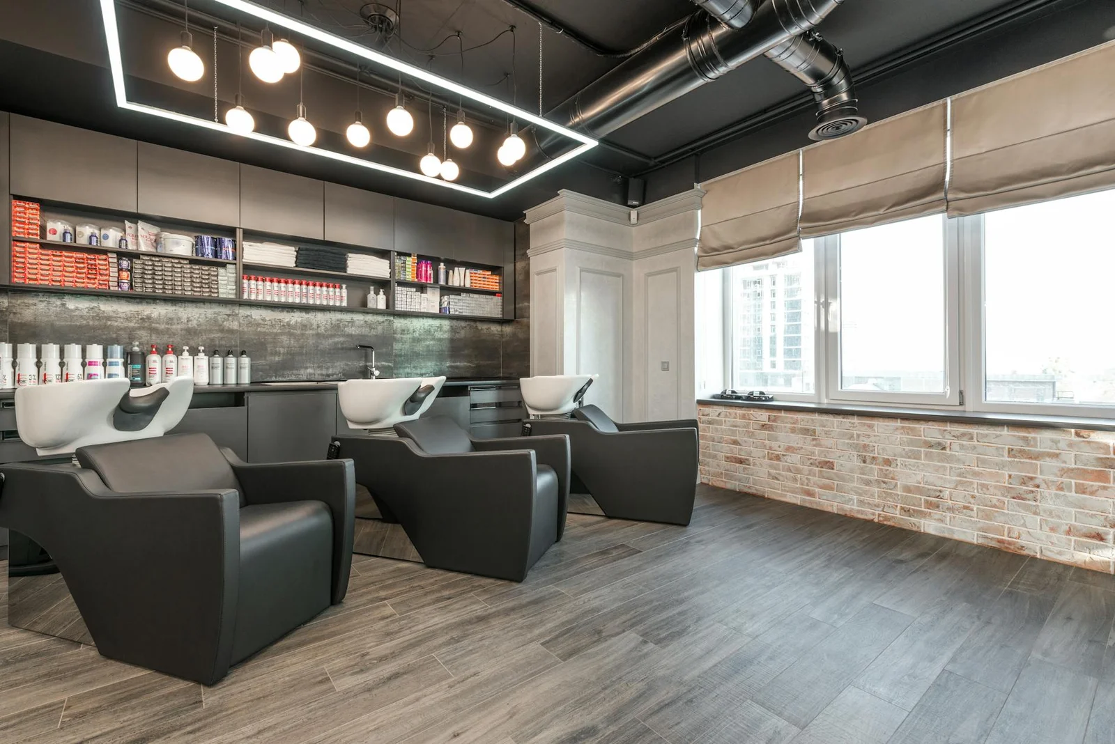 Ghế da hiện đại kèm bồn gội đầu trong salon rộng rãi nhiều cửa sổ, bố trí ngăn nắp dưới ánh đèn chuyên nghiệp. | Thiết kế nội thất 24