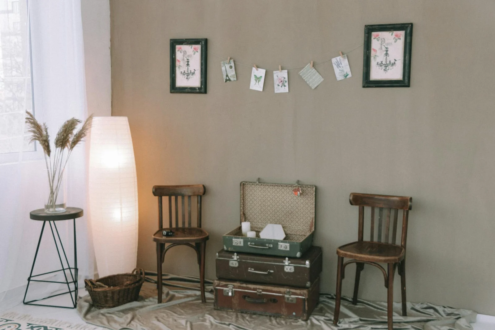 Căn phòng ấm cúng phong cách cổ điển điểm xuyết ghế gỗ, vali xếp chồng và tranh treo tường nghệ thuật. | Thiết kế nội thất 24