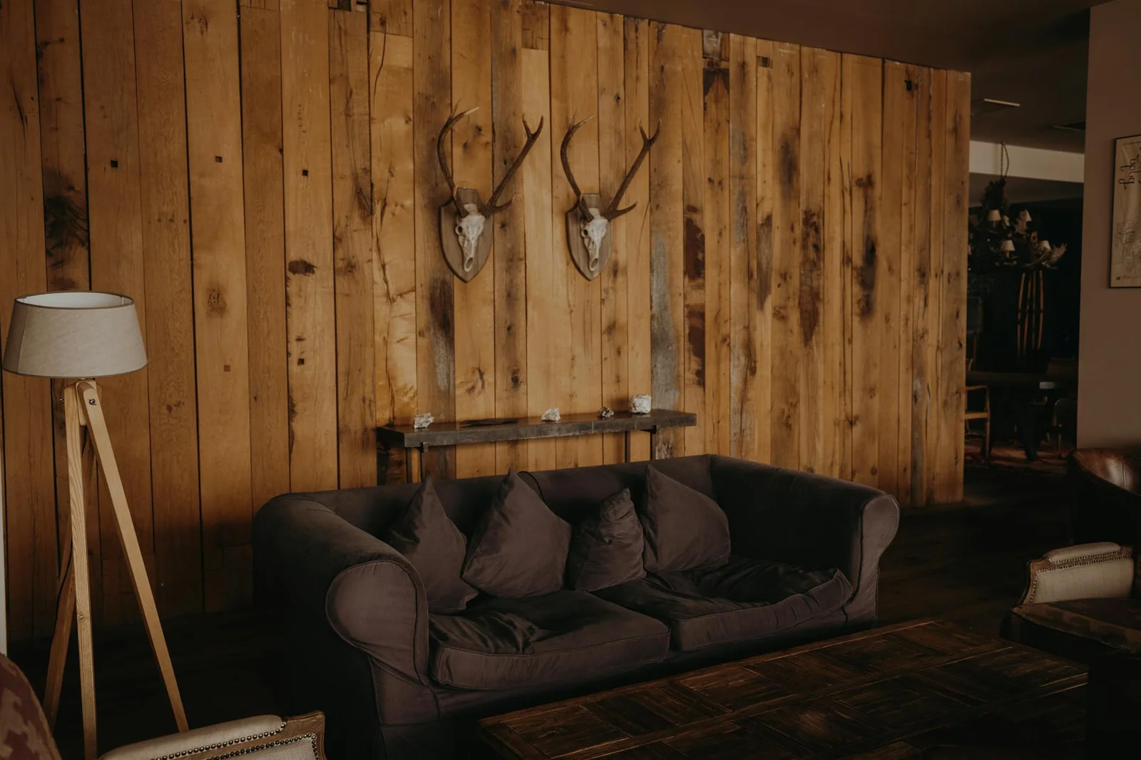 Phòng khách ấm áp với bức tường gỗ thô mộc và bộ sofa êm ái, tạo nên chốn nghỉ ngơi lý tưởng cho gia đình. | Thiết kế nội thất 24