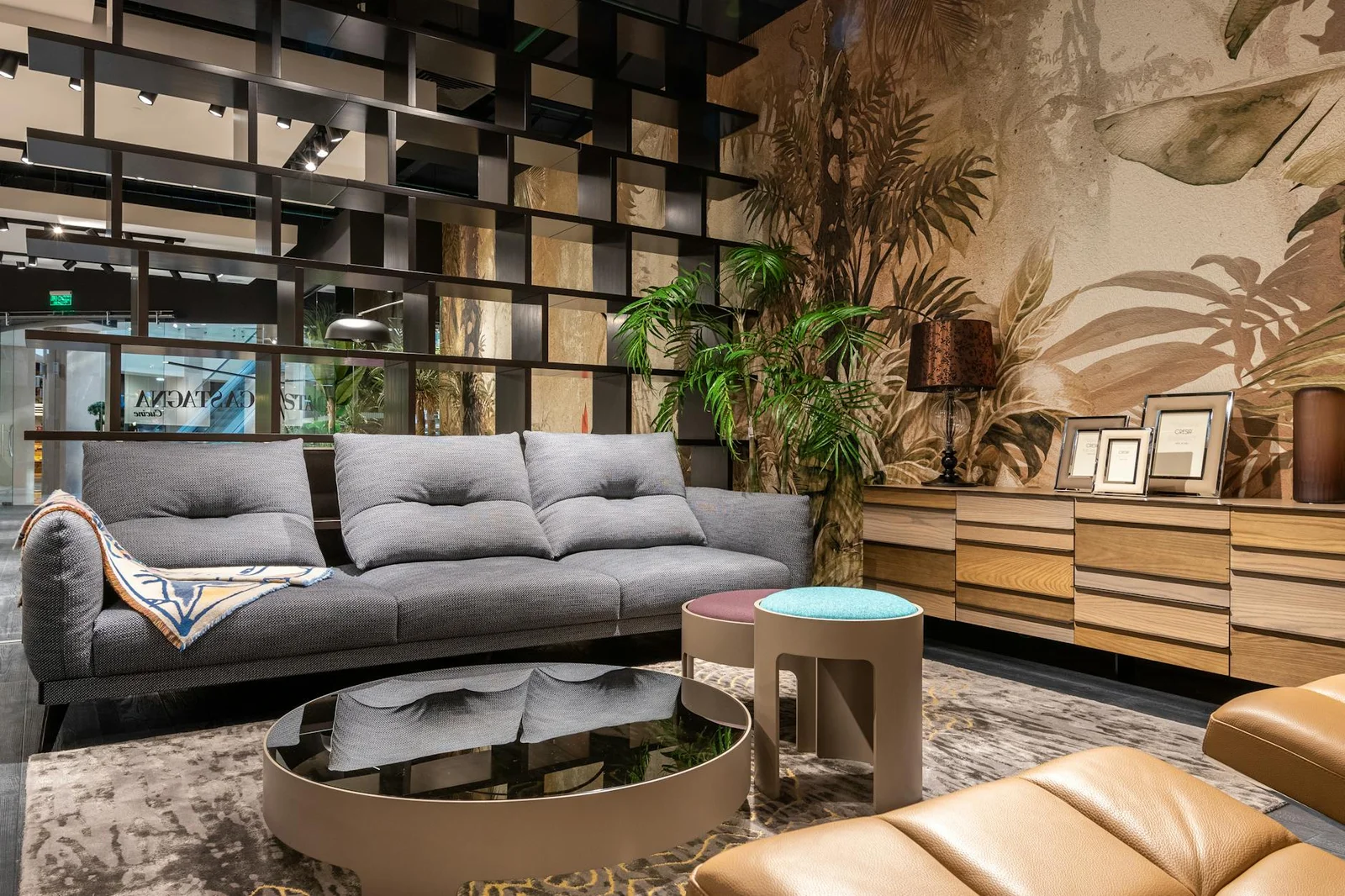 Không gian phòng khách sang trọng kết hợp sofa êm ái, bàn gương lấp lánh cùng giấy dán tường họa tiết nhiệt đới ấn tượng. | Thiết kế nội thất 24