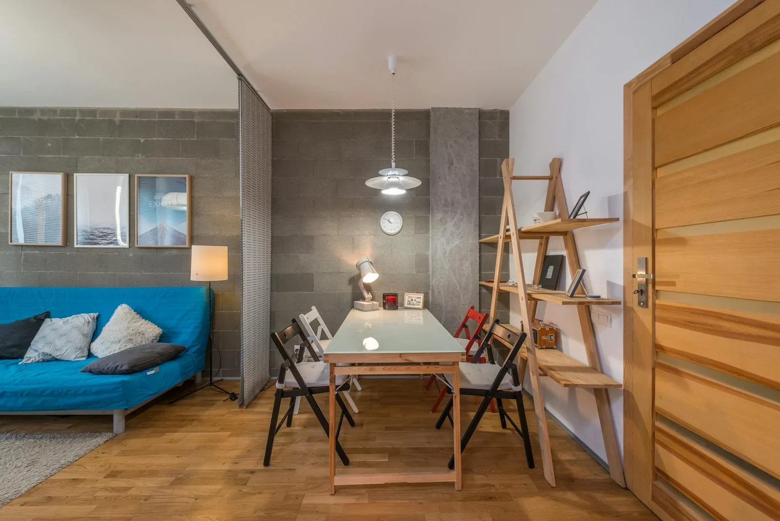 Phòng khách ấm cúng bài trí bàn gỗ lớn cùng ghế màu sắc nổi bật, kệ trang trí và sofa êm ái hài hòa. | Thiết kế nội thất 24