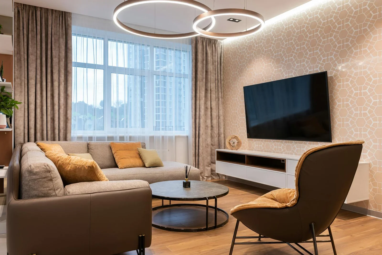 Bố trí nội thất khoa học với sofa mềm mại cạnh cửa sổ, bàn tròn tiện lợi và tivi treo tường đối diện cầu thang. | Thiết kế nội thất 24