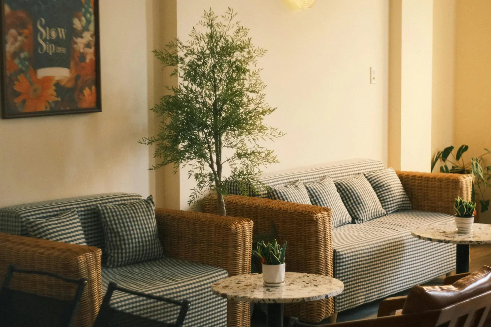 Phòng khách ấm cúng nổi bật với sofa họa tiết caro, cây xanh tươi mát và ánh sáng vàng nhẹ nhàng ôm trọn cầu thang. | Thiết kế nội thất 24