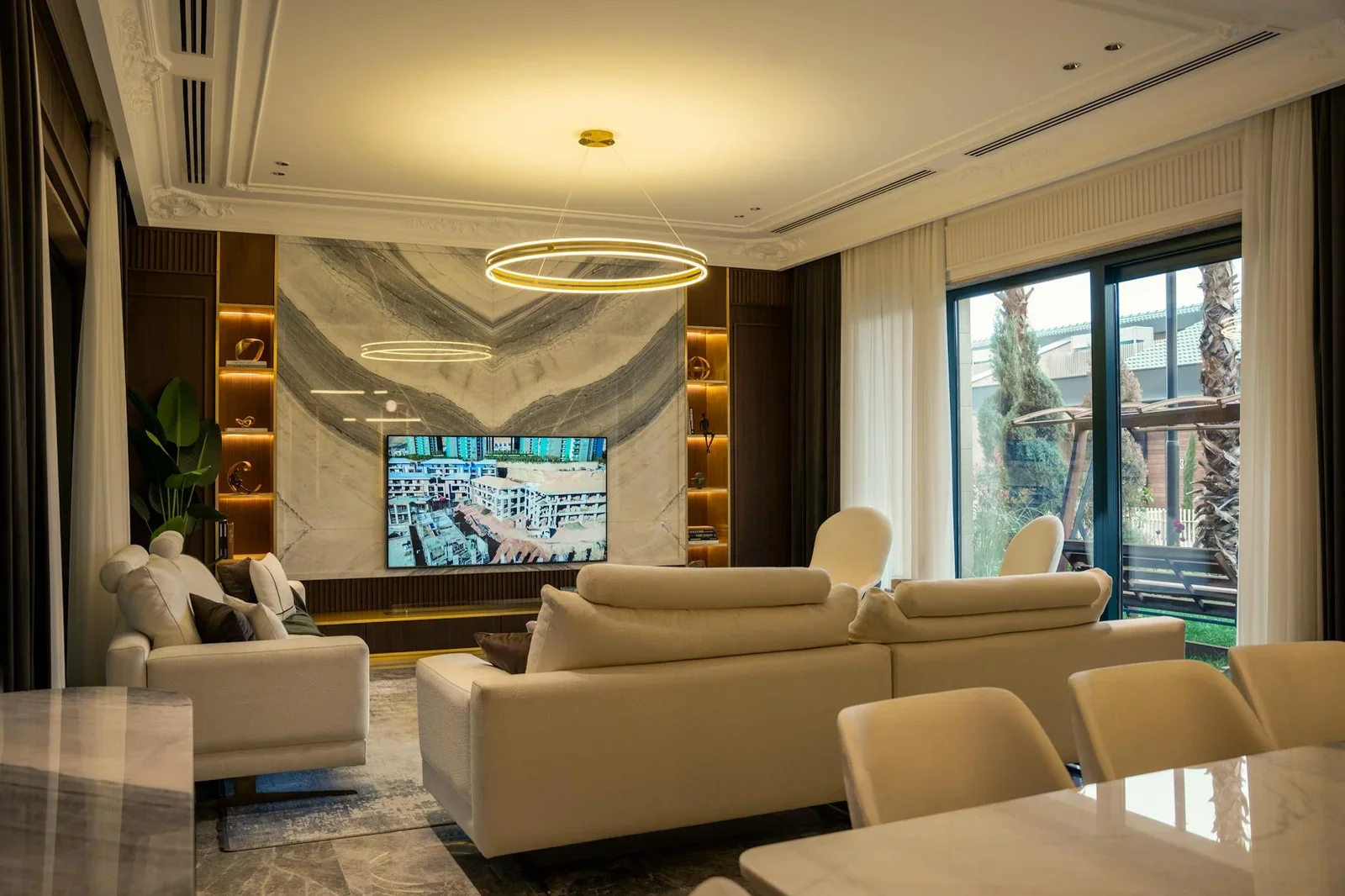 Không gian thanh lịch tích hợp tivi màn hình lớn cùng hệ đèn nghệ thuật và sofa gỗ óc chó cao cấp sang trọng. | Thiết kế nội thất 24