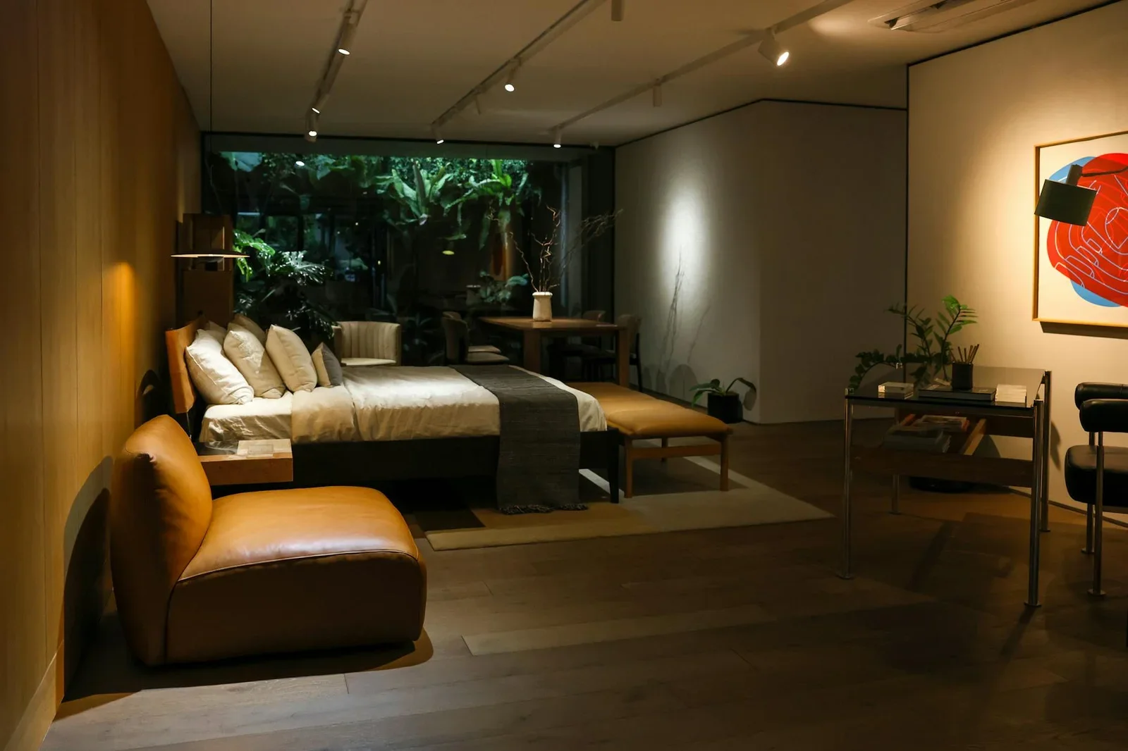 Thiết kế phòng ngủ hiện đại kết hợp cây xanh, ghế da và tranh nghệ thuật, nổi bật dưới ánh đèn vàng ấm áp. | Thiết kế nội thất 24