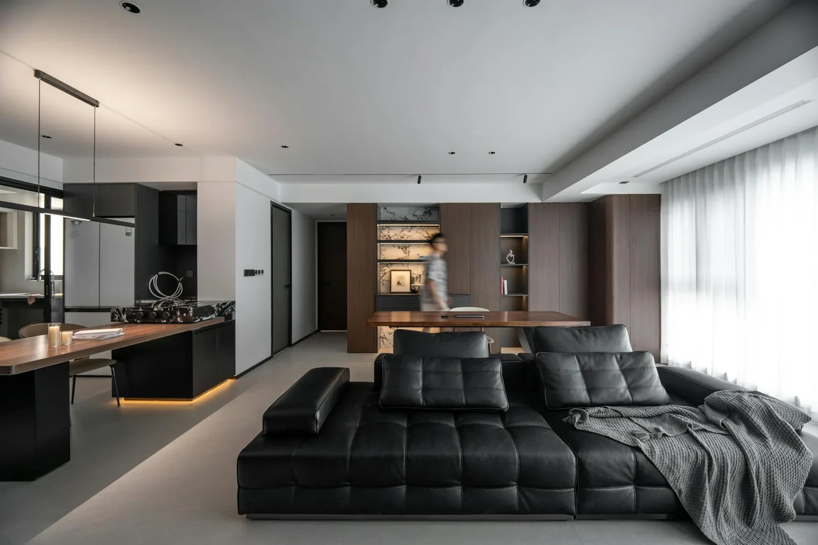 Sofa đen tương phản hài hòa với khu bếp mở, thiết kế hiện đại giúp phân chia không gian khéo léo mà vẫn thông thoáng tự nhiên. | Thiết kế nội thất 24