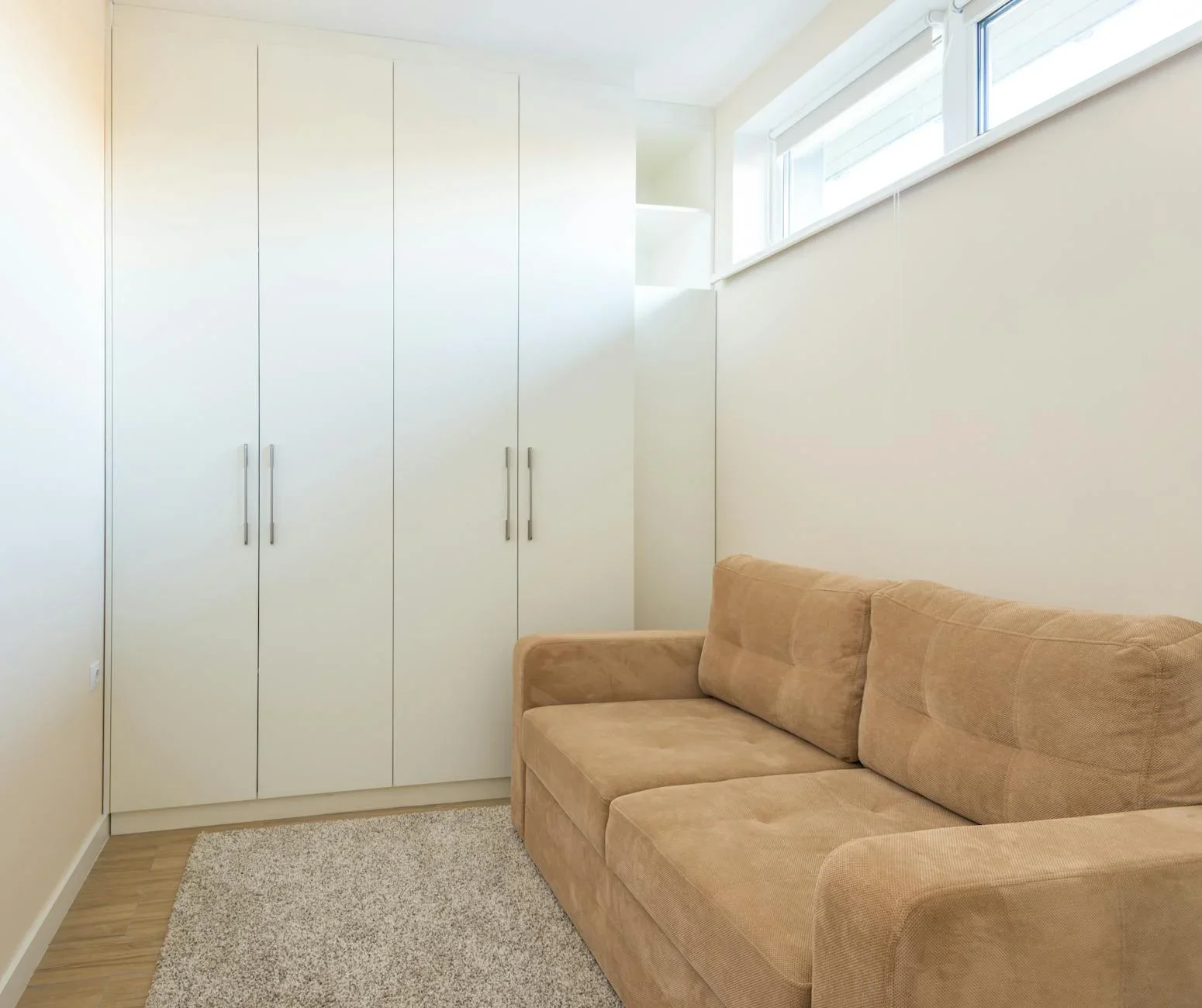Thiết kế tối giản với sofa màu be và tủ trắng gọn gàng, tối ưu diện tích cho không gian chung. | Thiết kế nội thất 24