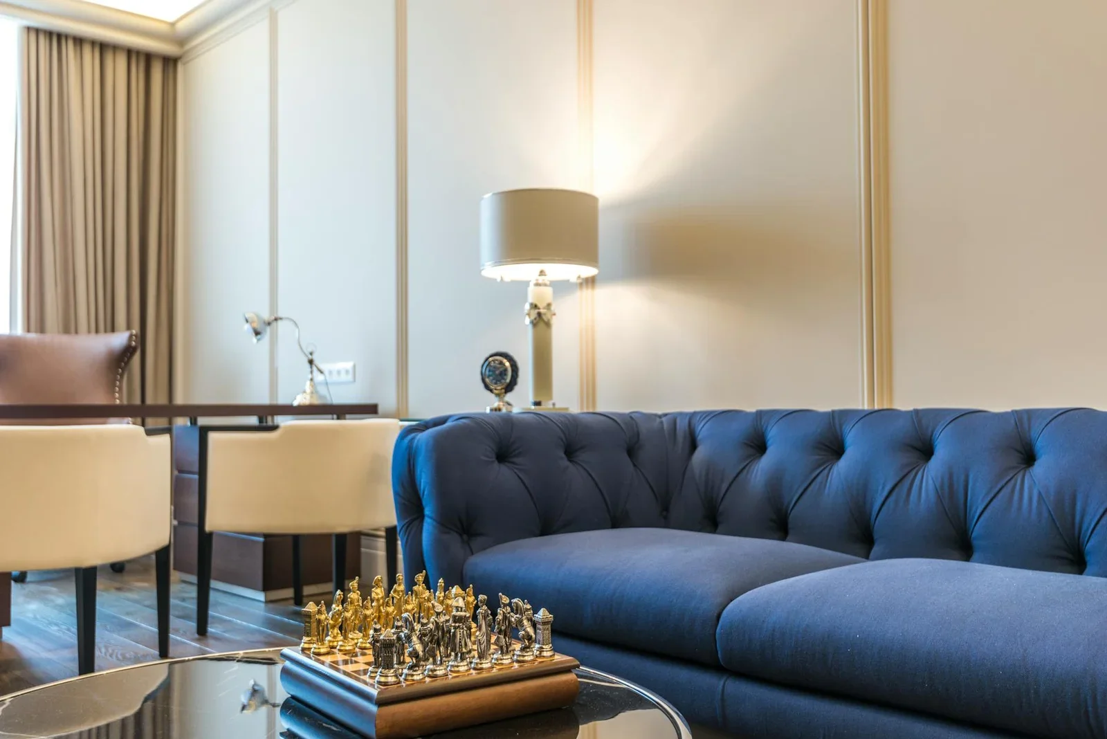 Sofa xanh nổi bật cùng bàn cờ và đèn trang trí hiện đại, tạo điểm nhấn nghệ thuật cho không gian sinh hoạt chung. | Thiết kế nội thất 24