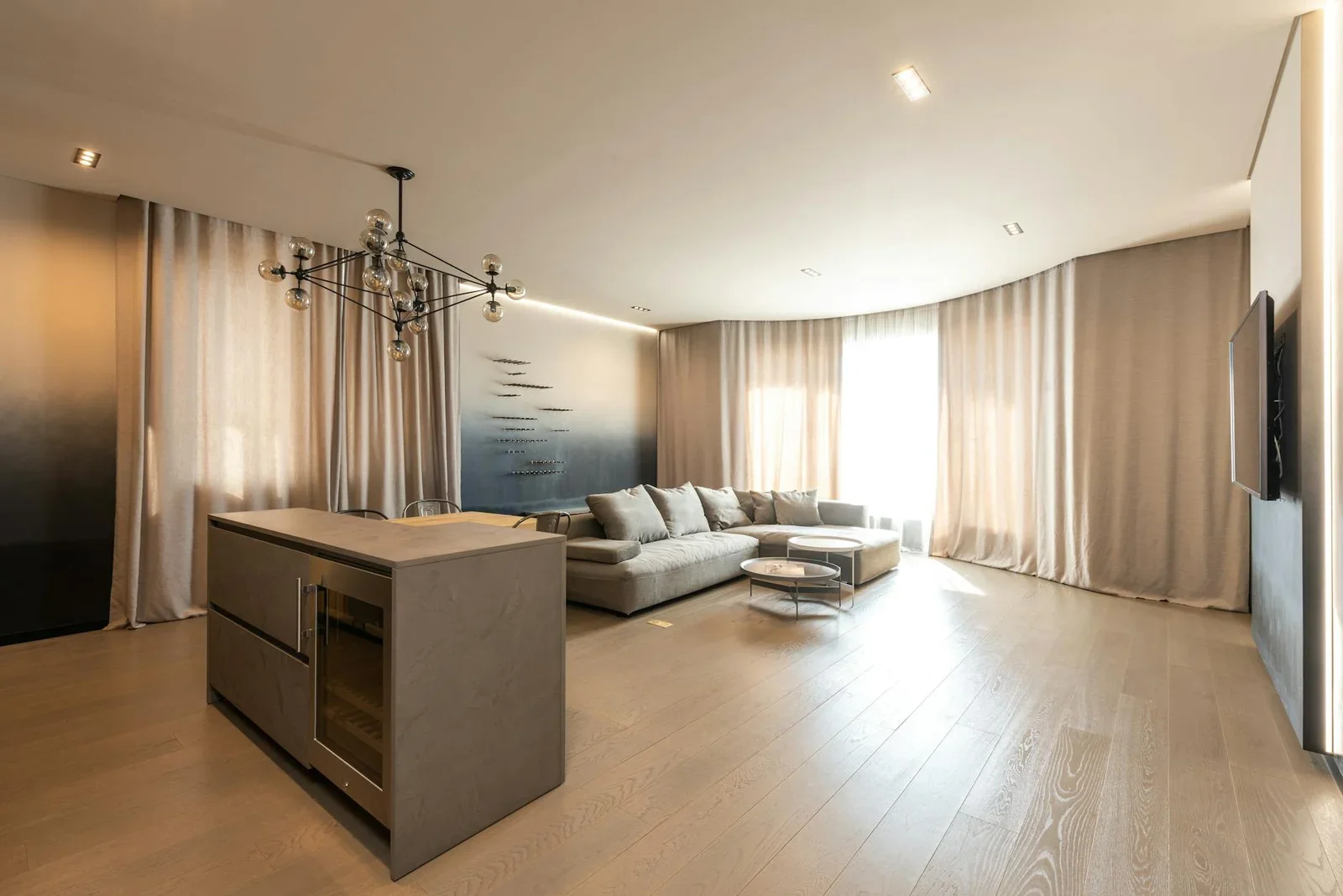 Quầy bar tiện ích cạnh sofa êm ái, tường trang trí cùng rèm cửa và tivi, tối ưu công năng cho mặt bằng rộng rãi. | Thiết kế nội thất 24