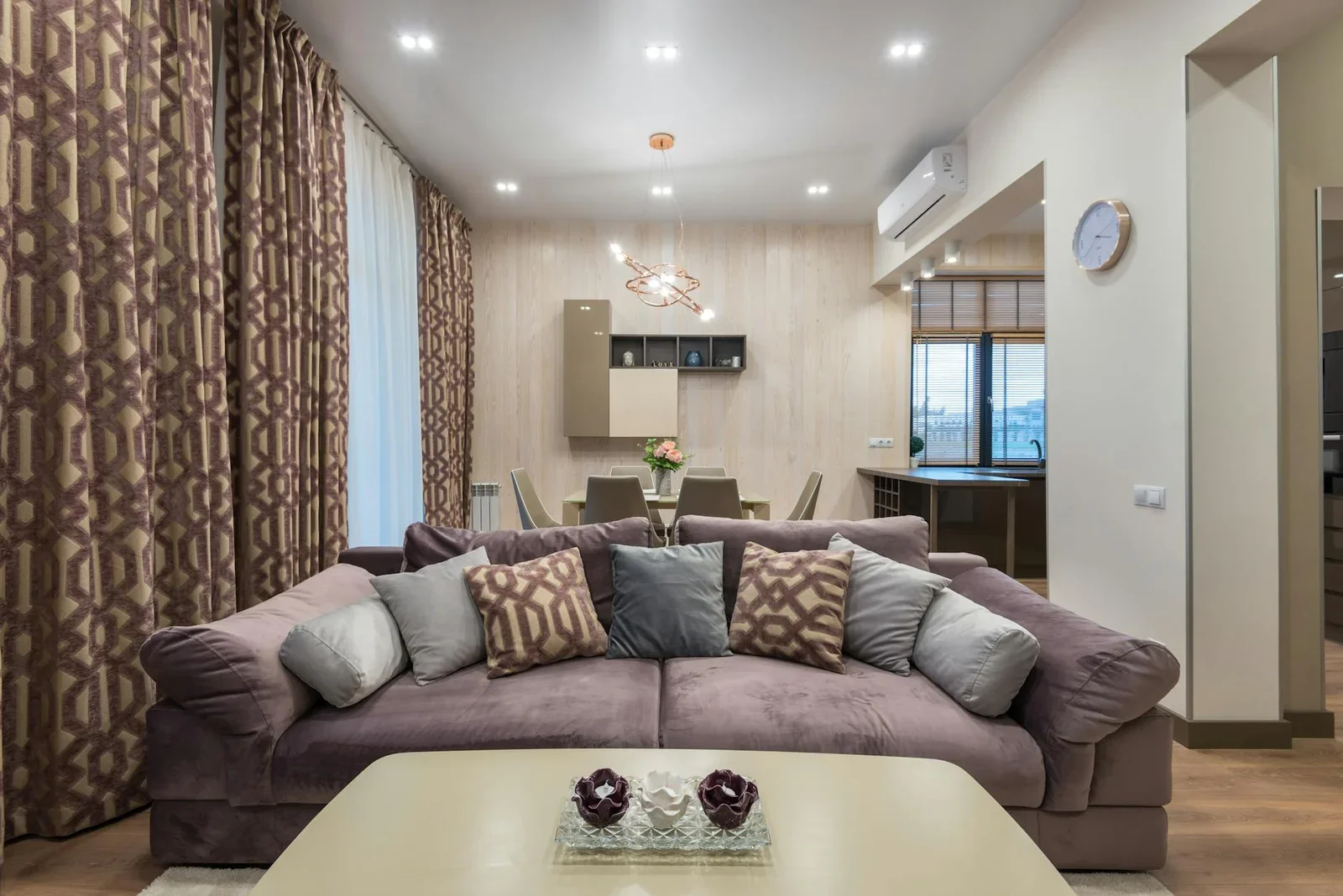 Sofa êm ái phối cùng gối tựa mềm mại và bàn trà tinh tế, kiến tạo phòng khách xám ấm cúng liền kề bàn ăn. | Thiết kế nội thất 24