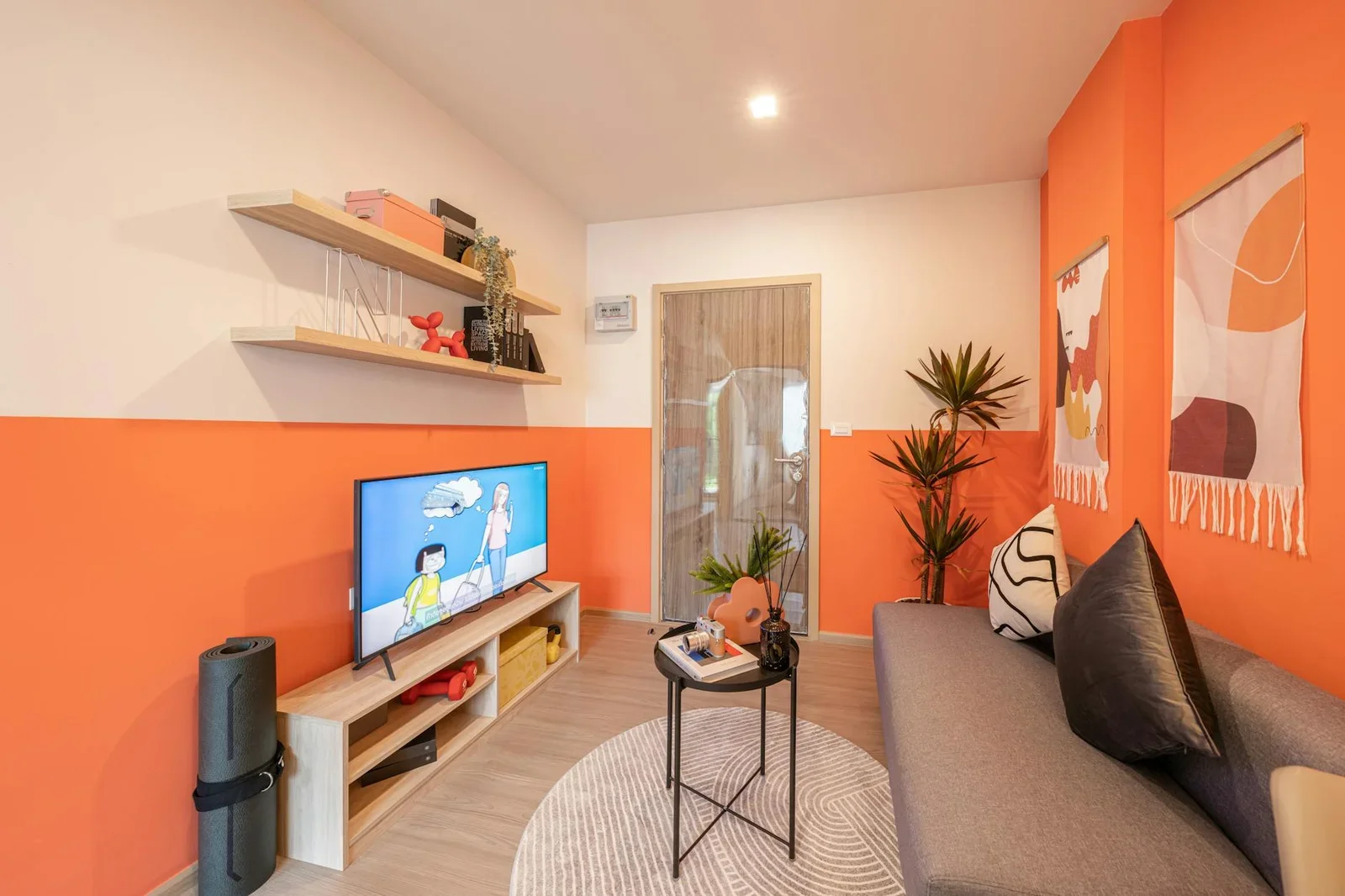 Không gian phòng khách hiện đại với tường cam ấm áp, decor tinh tế tạo cảm giác quây quần thân thuộc. | Thiết kế nội thất 24