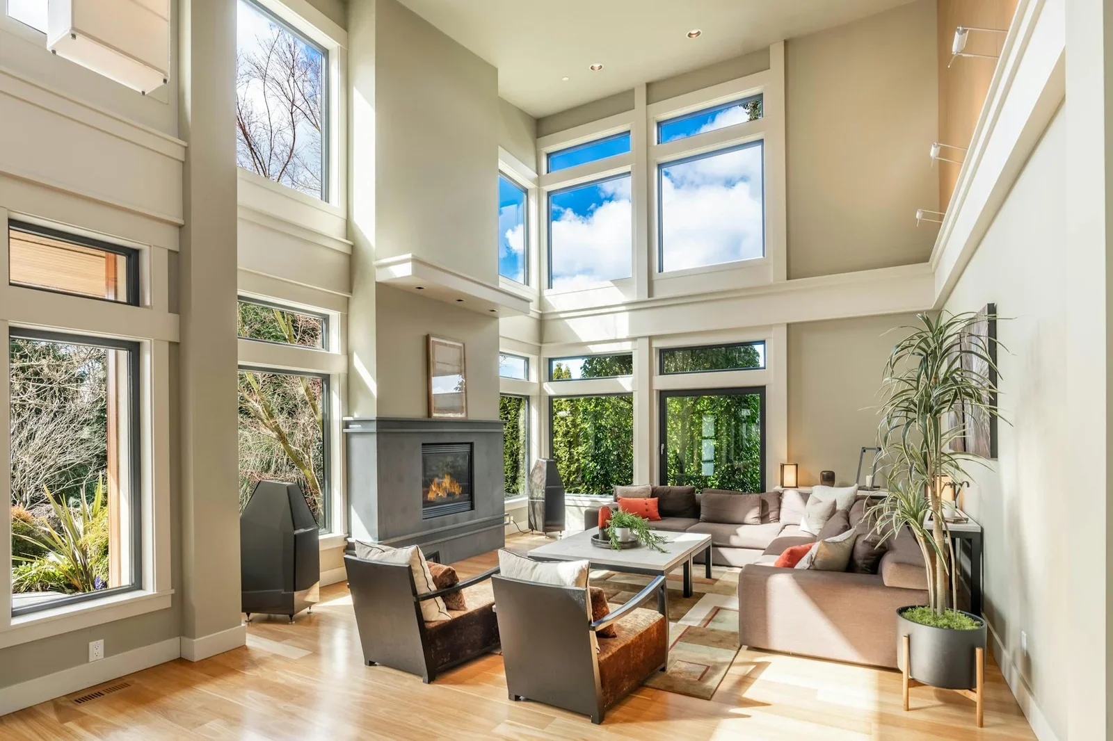 Phòng khách thoáng đãng tràn ngập ánh sáng nhờ cửa sổ cao, kết hợp lò sưởi ấm cúng và decor thanh lịch. | Thiết kế nội thất 24