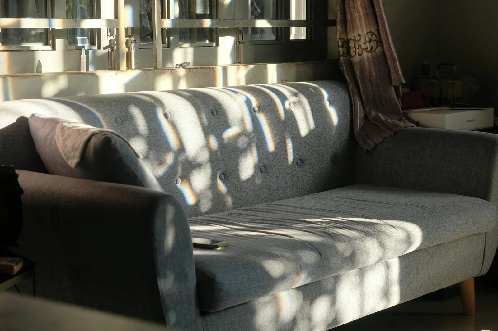 Ghế sofa xám hiện đại trong phòng khách tràn nắng nổi bật nhờ thiết kế nội thất tinh tế mang vẻ đẹp sang trọng. | Thiết kế nội thất 24
