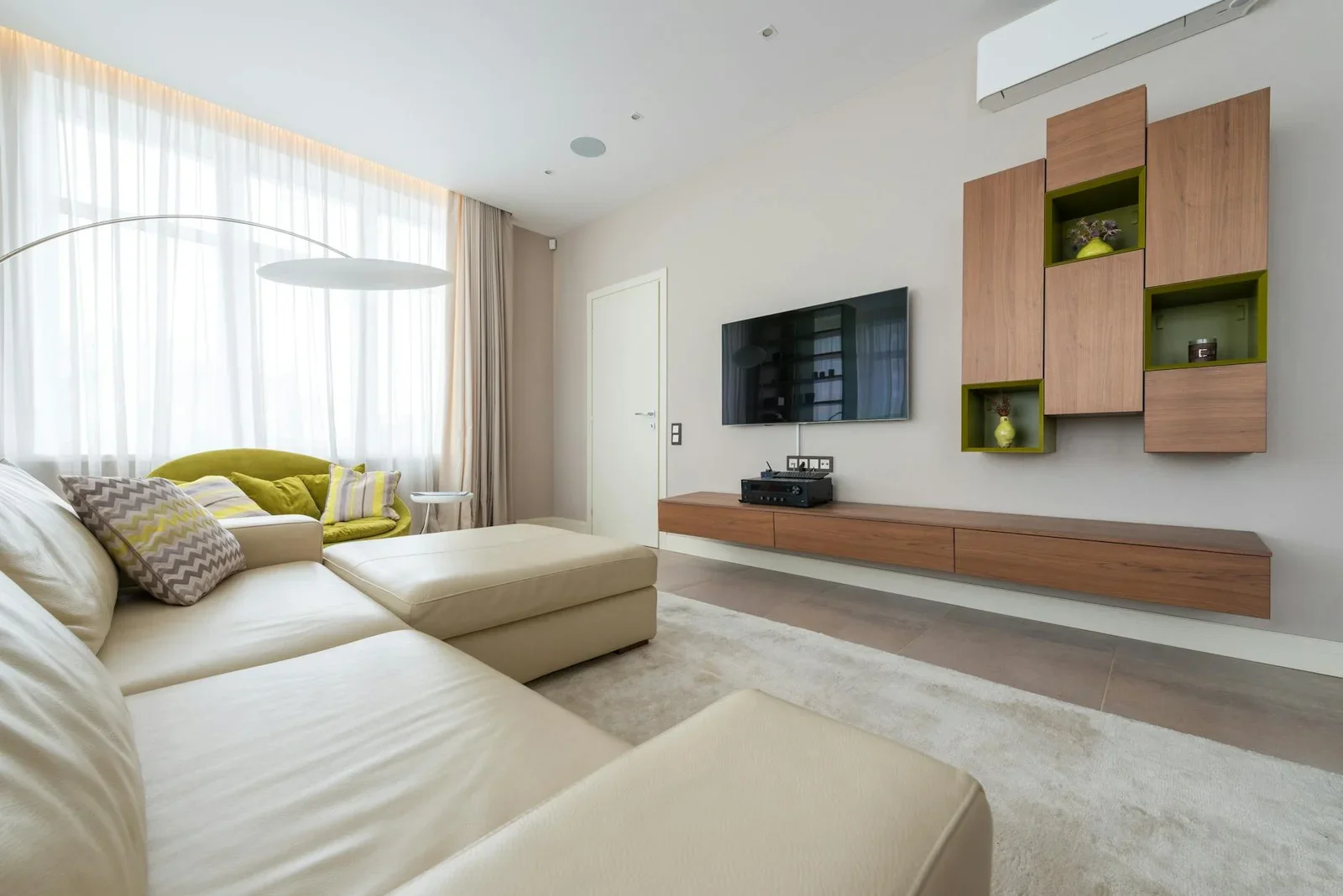 Sofa êm ái điểm xuyết gối tựa sang trọng, kết hợp tivi treo tường tinh tế, kiến tạo phòng khách tân cổ điển rộng rãi chuẩn cao cấp. | Thiết kế nội thất 24