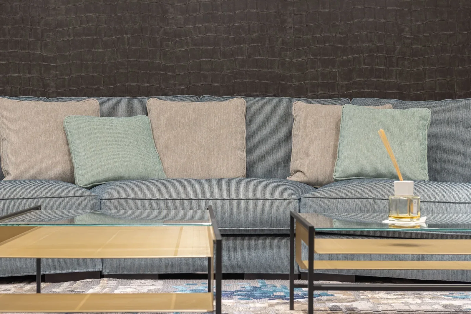 Ghế sofa xám êm ái đặt cạnh bàn trà mặt kính trong suốt, tôn lên vẻ đẹp hiện đại và sự tiện nghi cho không gian. | Thiết kế nội thất 24