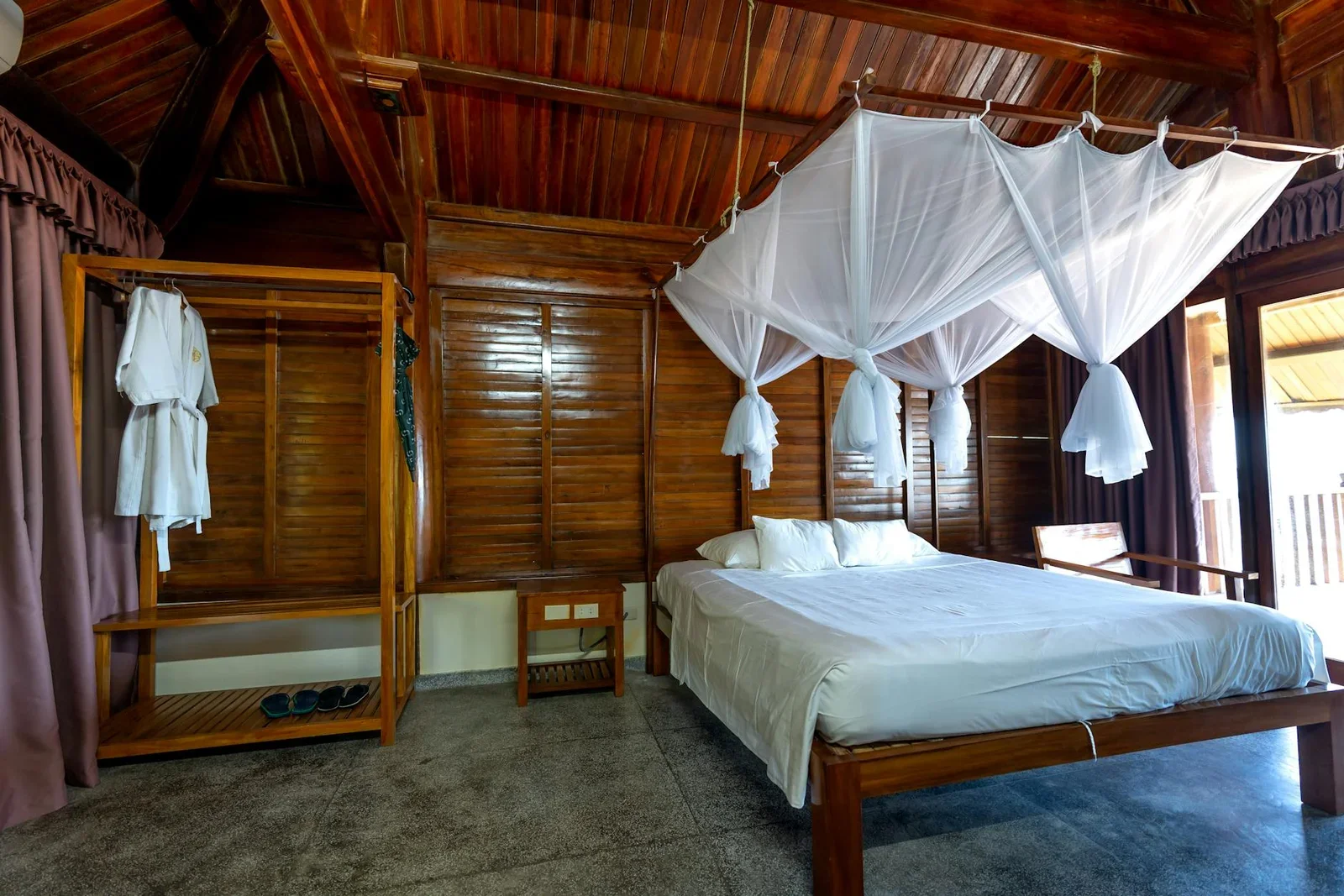 Phòng ngủ biệt thự cabin gỗ yên bình kết hợp giường màn và nội thất mộc mạc, mang đến giấc ngủ ngon trọn vẹn. | Thiết kế nội thất 24